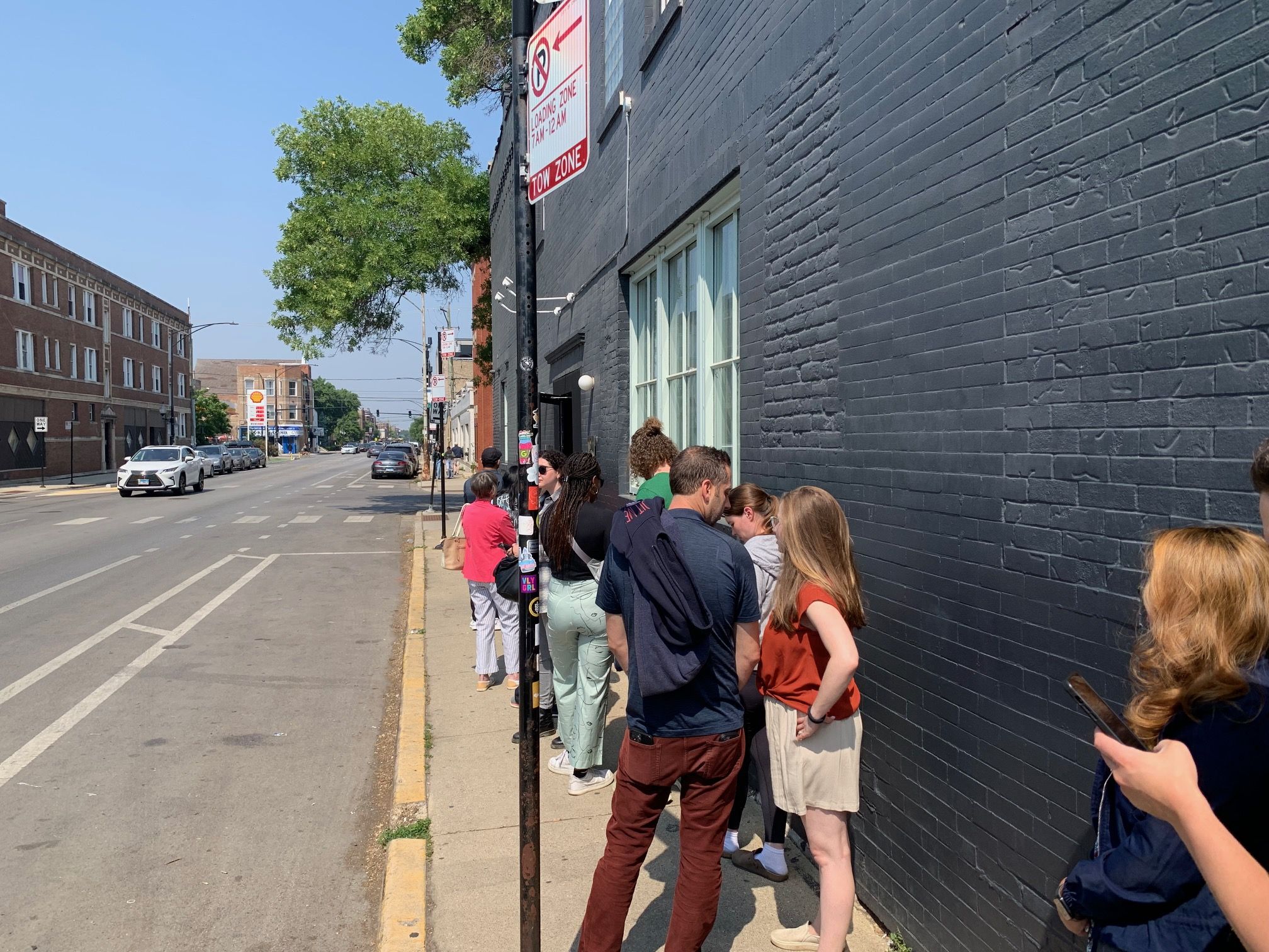 People waiting in a line to get into a restaurant. 