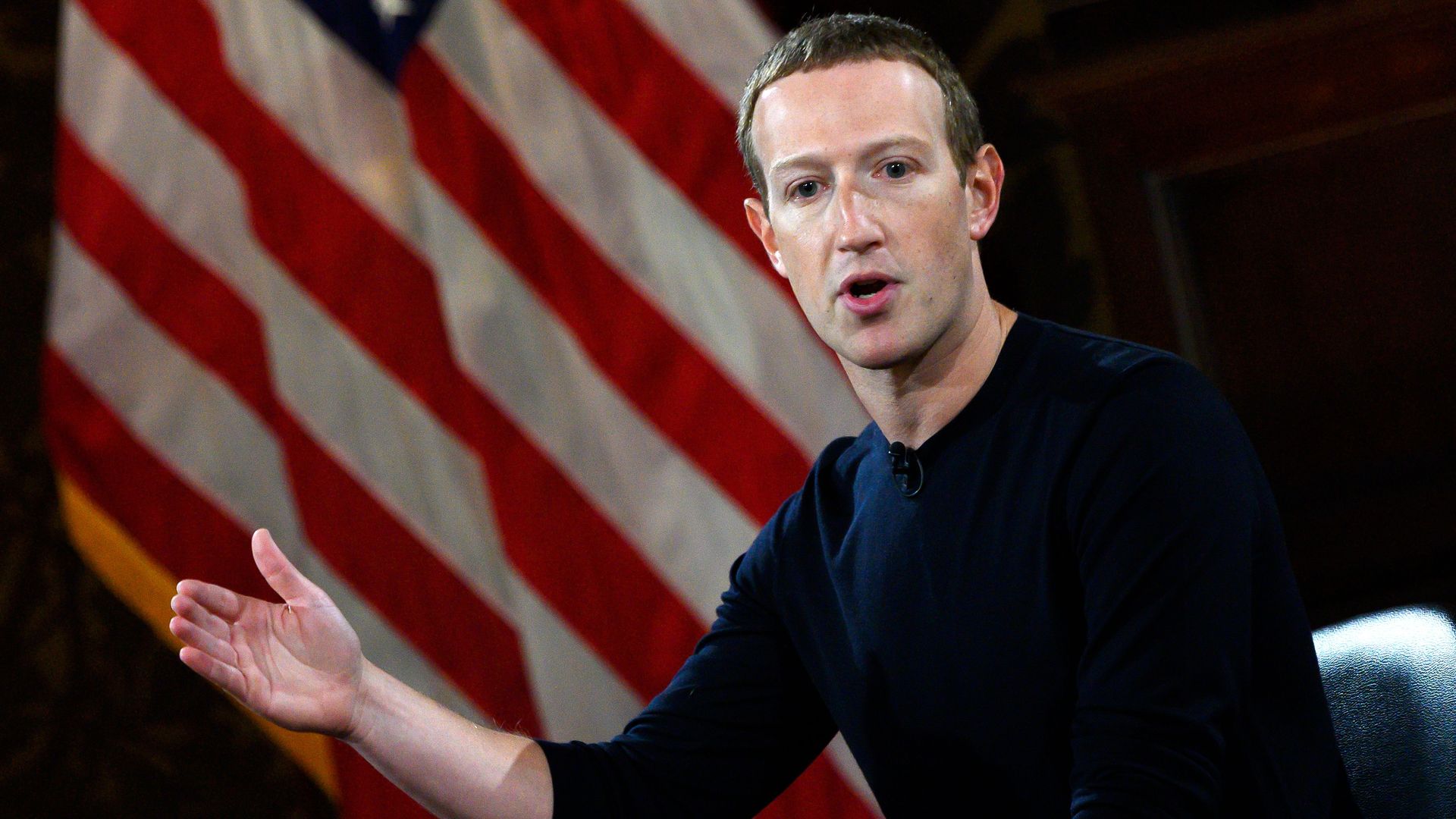 Photo of Facebook CEO Mark Zuckerberg speaking at Georgetown University standing in front of American flag