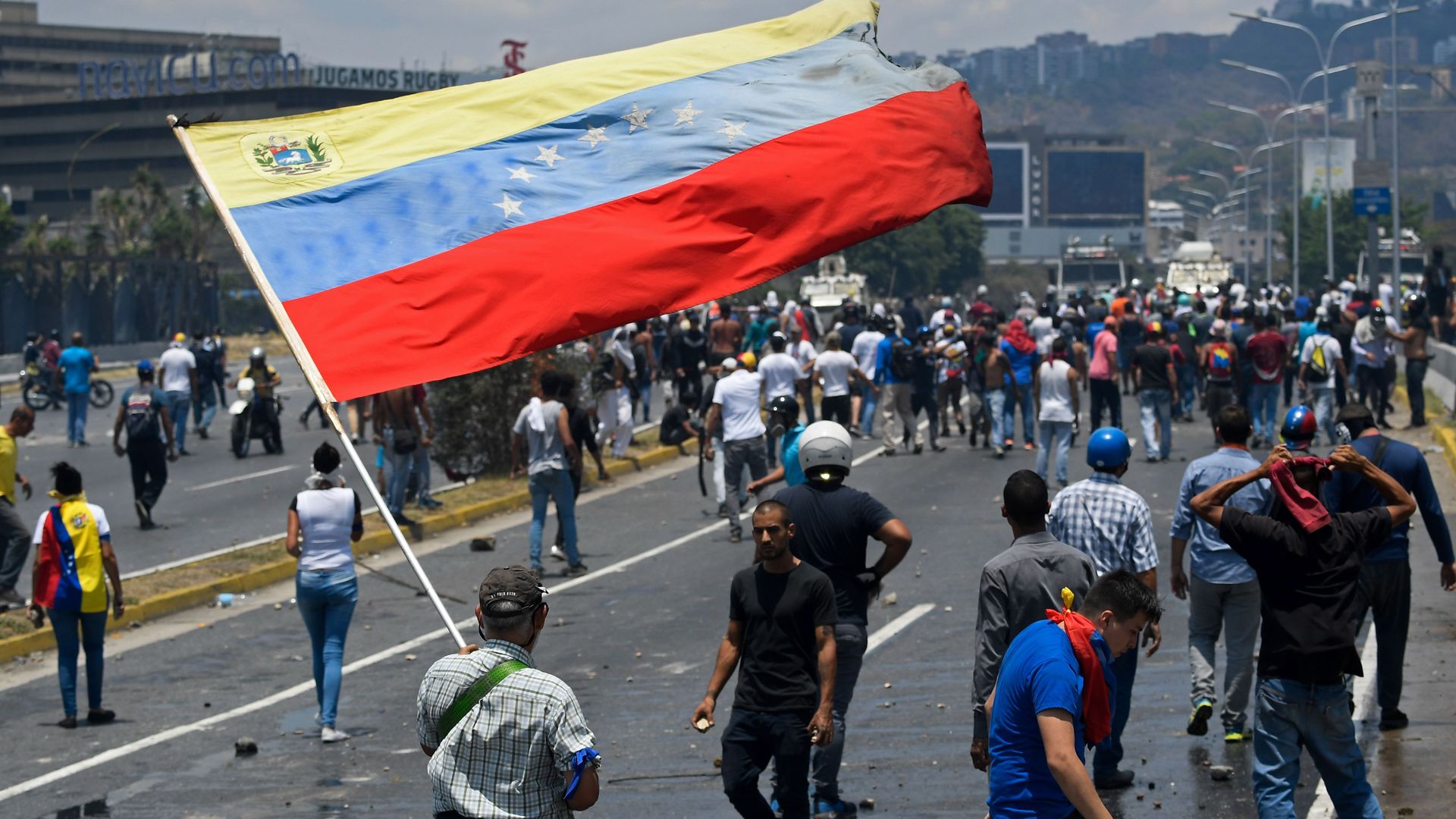 An opposition demonstrator waves a Venezuelan national flag during clashes with soldiers loyal to Venezuelan President Nicolas Maduro.