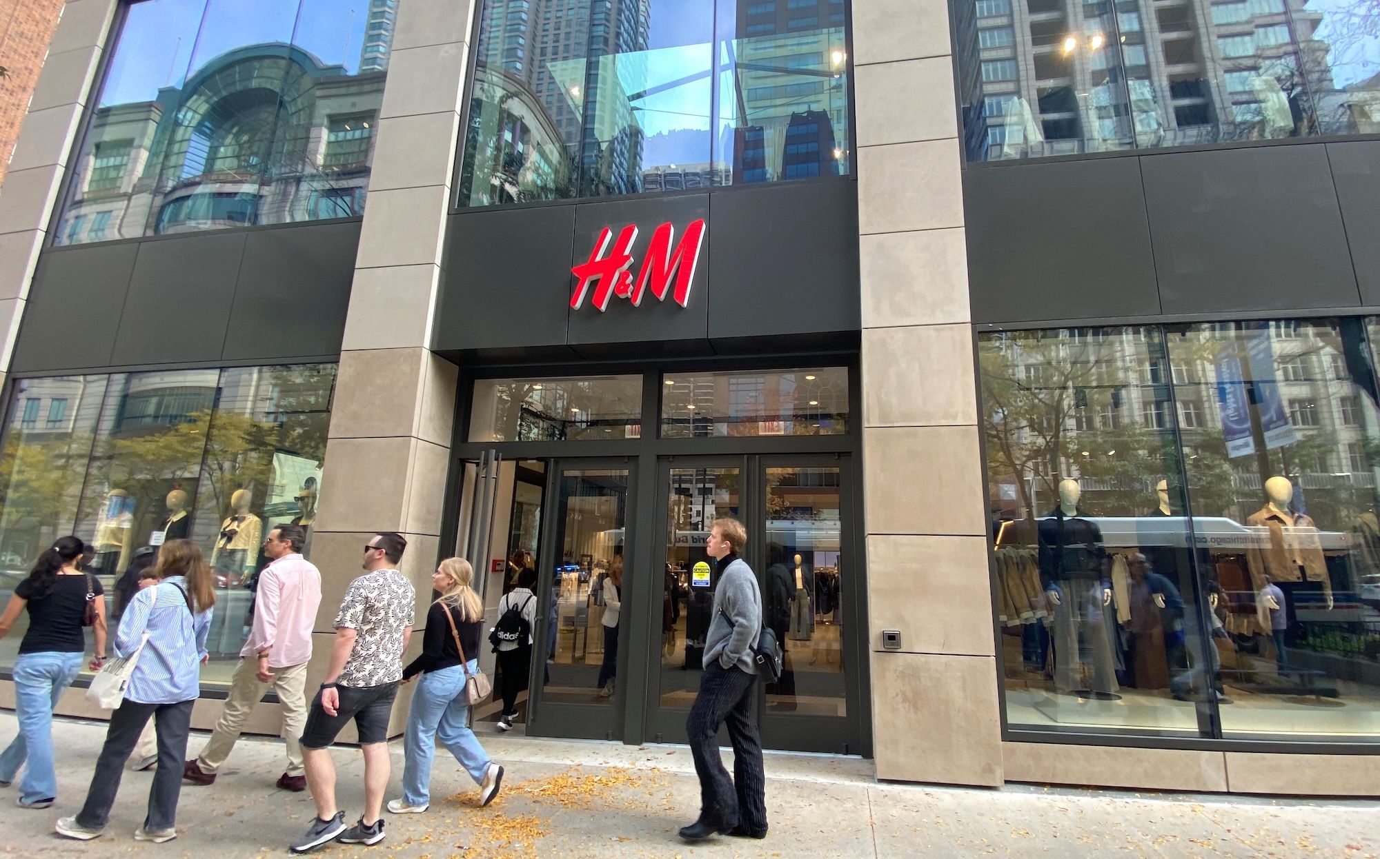 Front of H&M store with people walking in front of it.