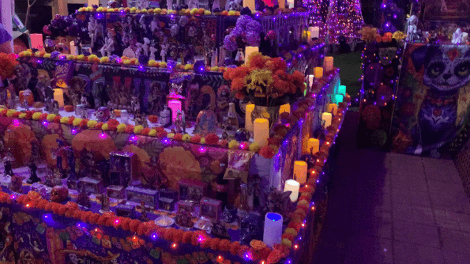 GIF of an ornate, colorful altar with hundreds of photos at the top of it.