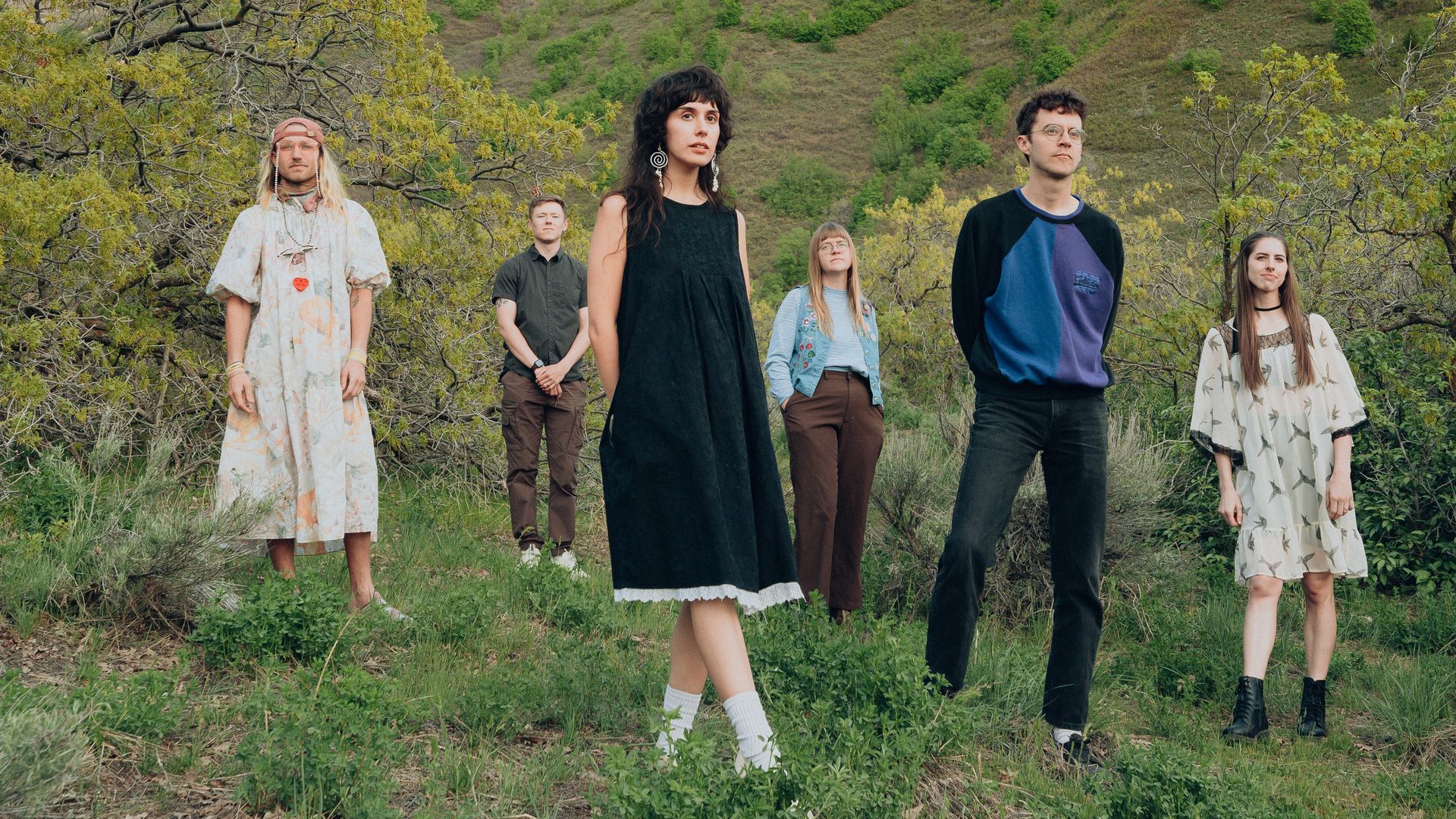 A group of six people standing in the outdoors. 