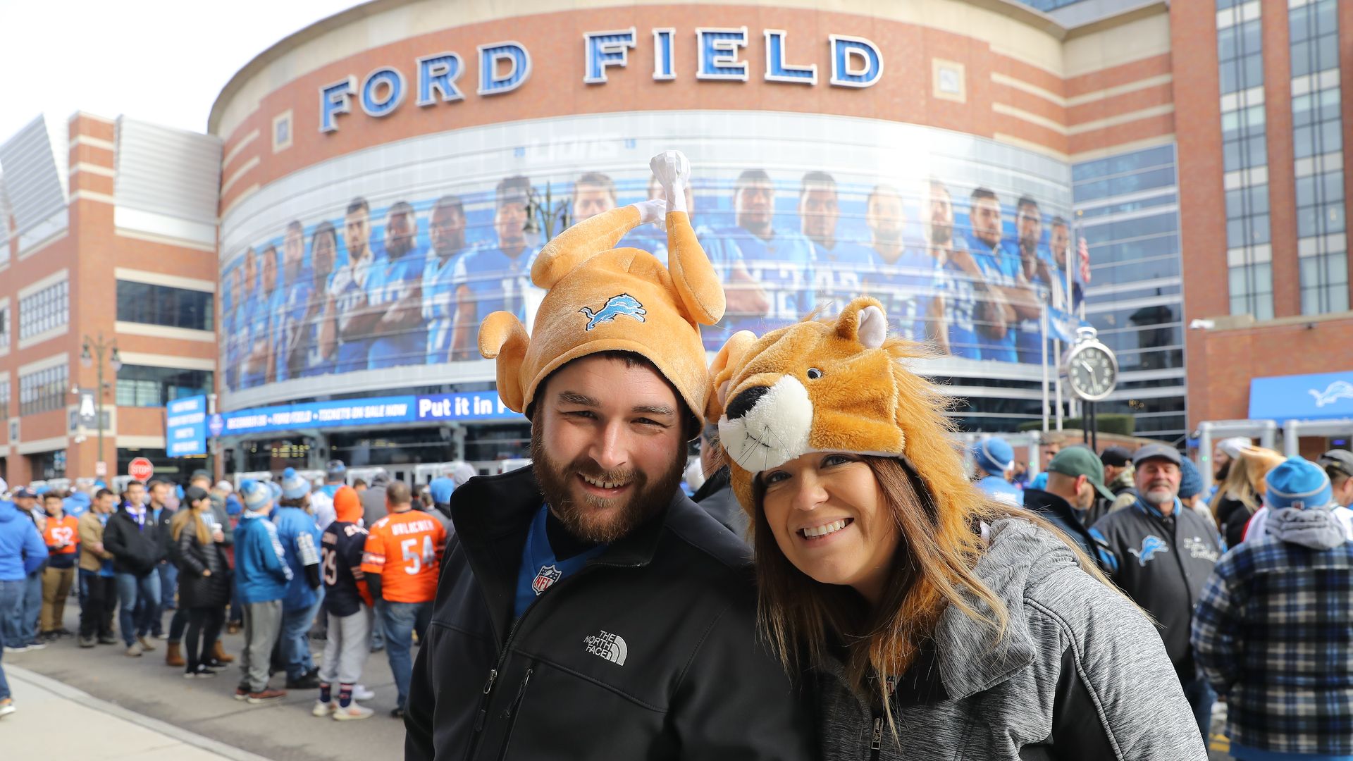 Detroit Lions fans pose for a photo outside of Ford Field prior to the NFL, Thanksgiving Day game between the Detroit Lions and the Chicago Bears on November 28, 2019 in Detroit, Michigan.
