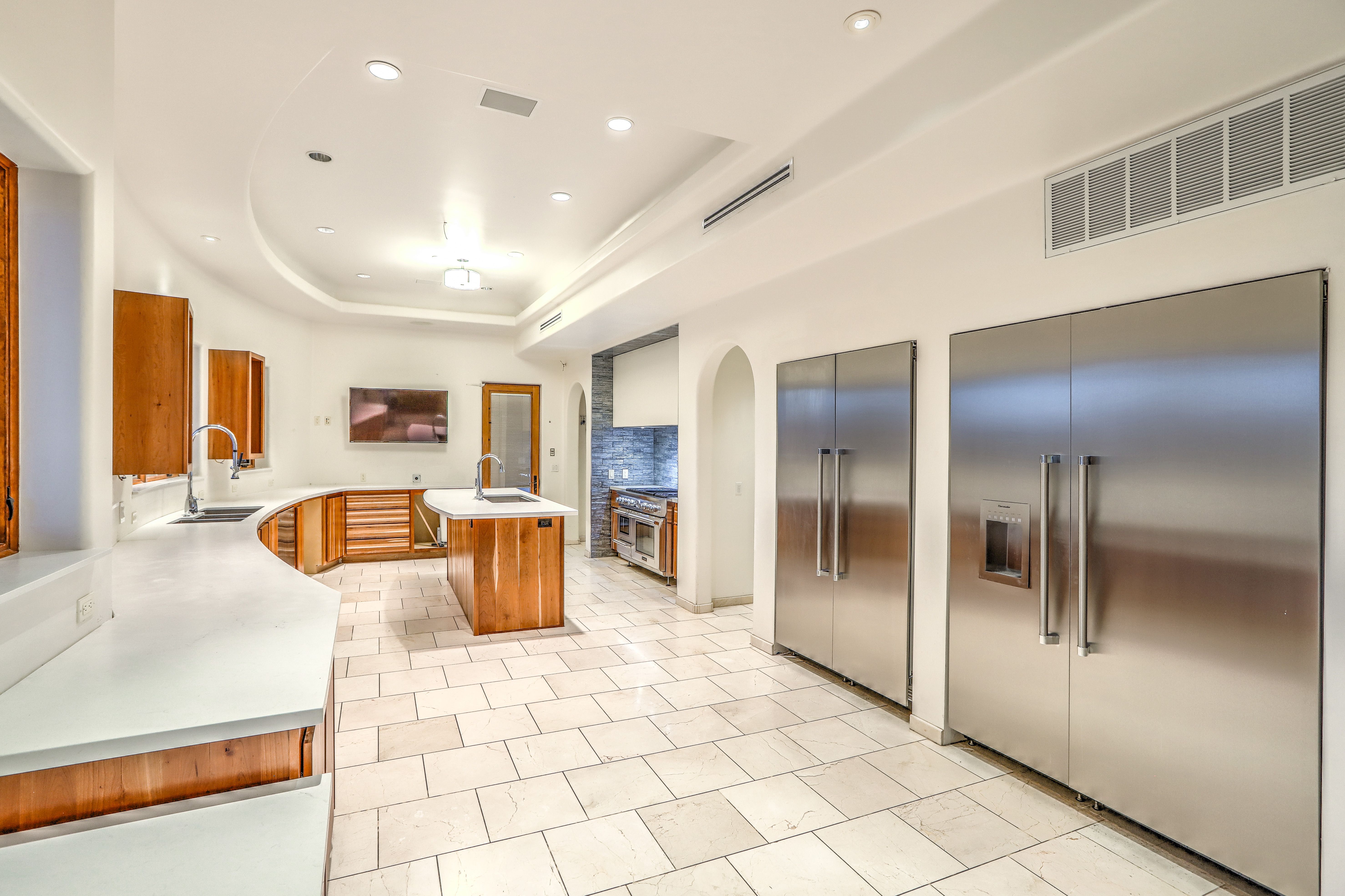 A kitchen with two large refrigerators. 