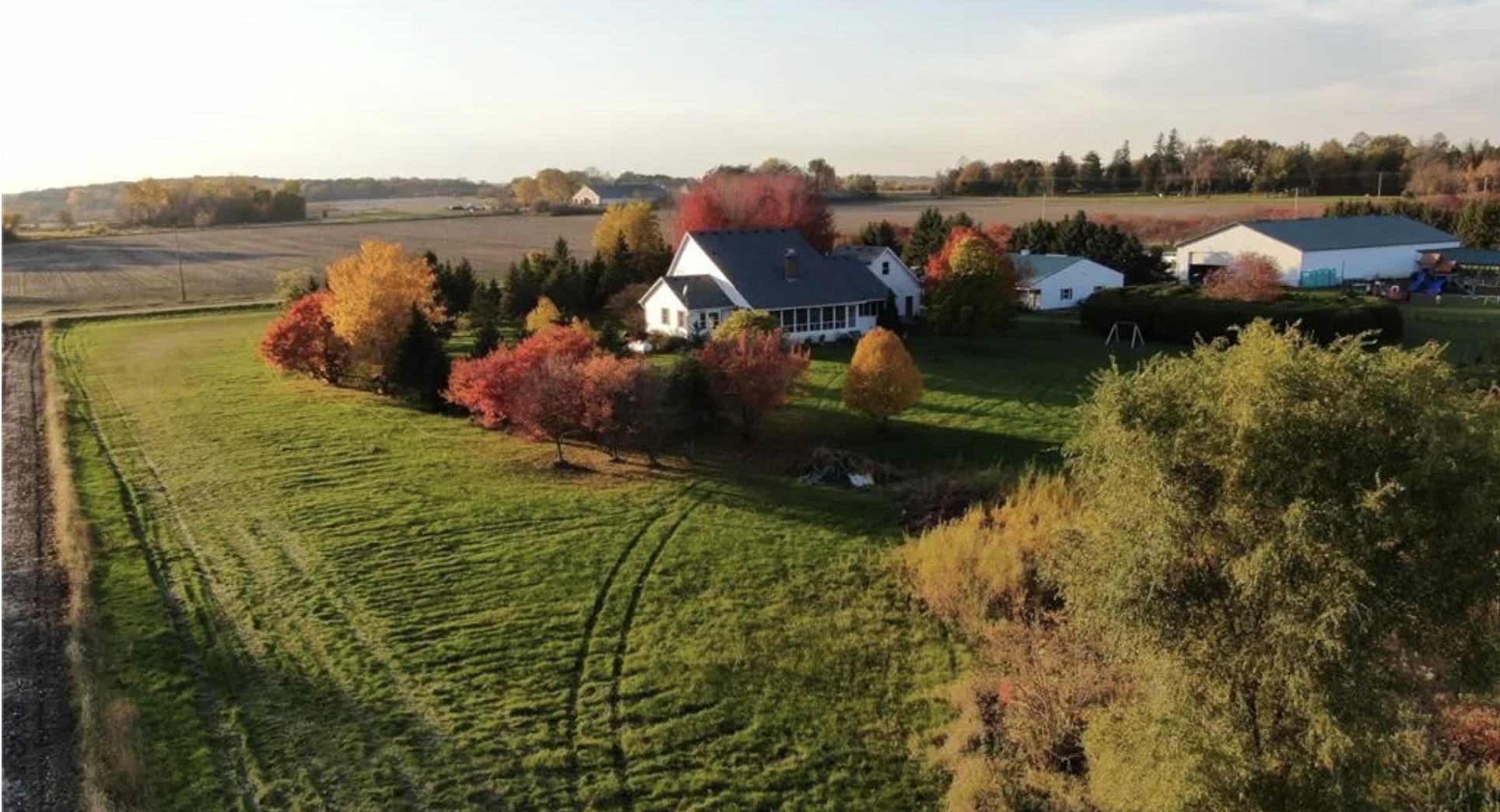 white house with trees and fields surrounding it