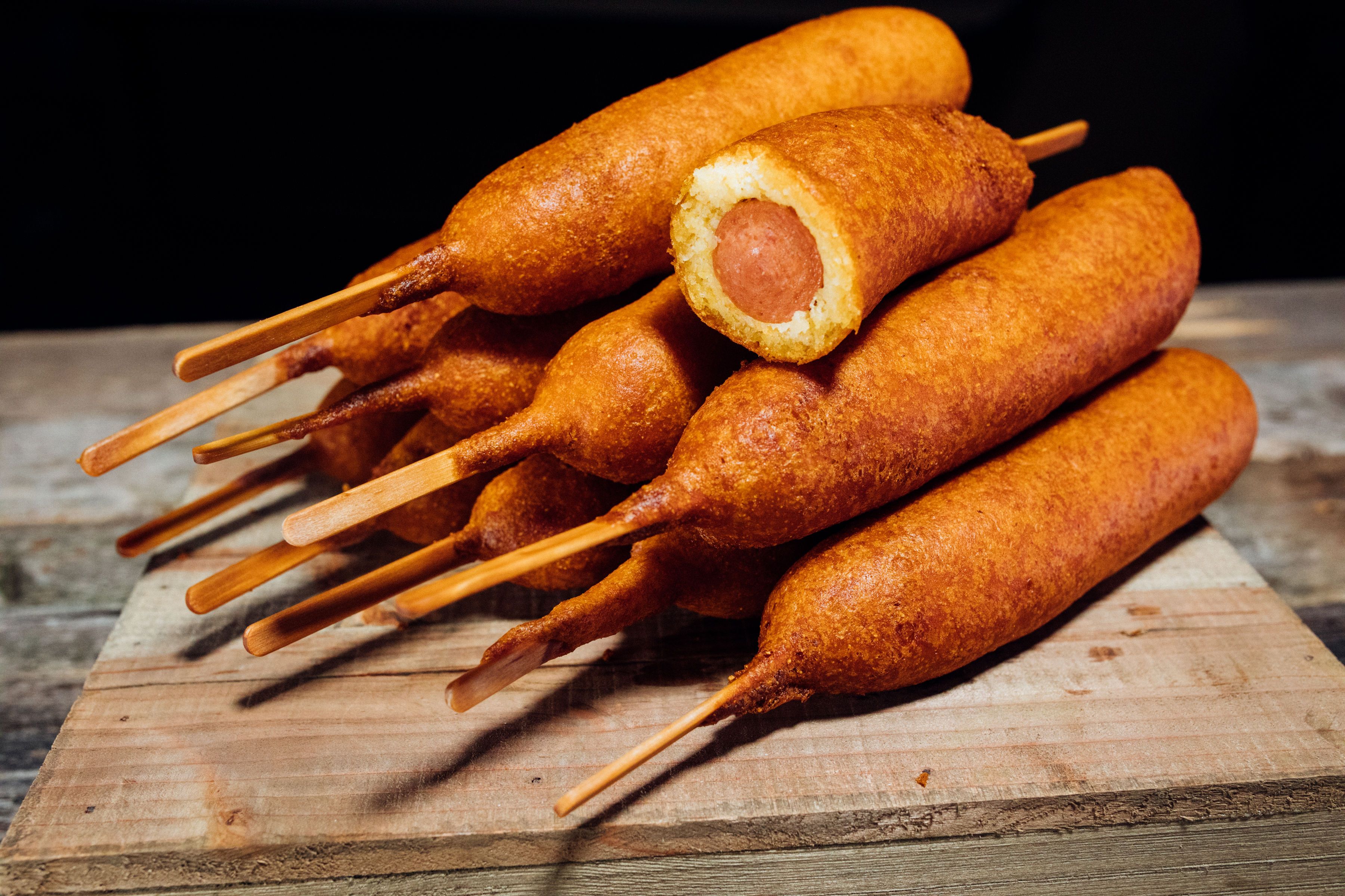 a stack of corn dogs with one cut open to see inside