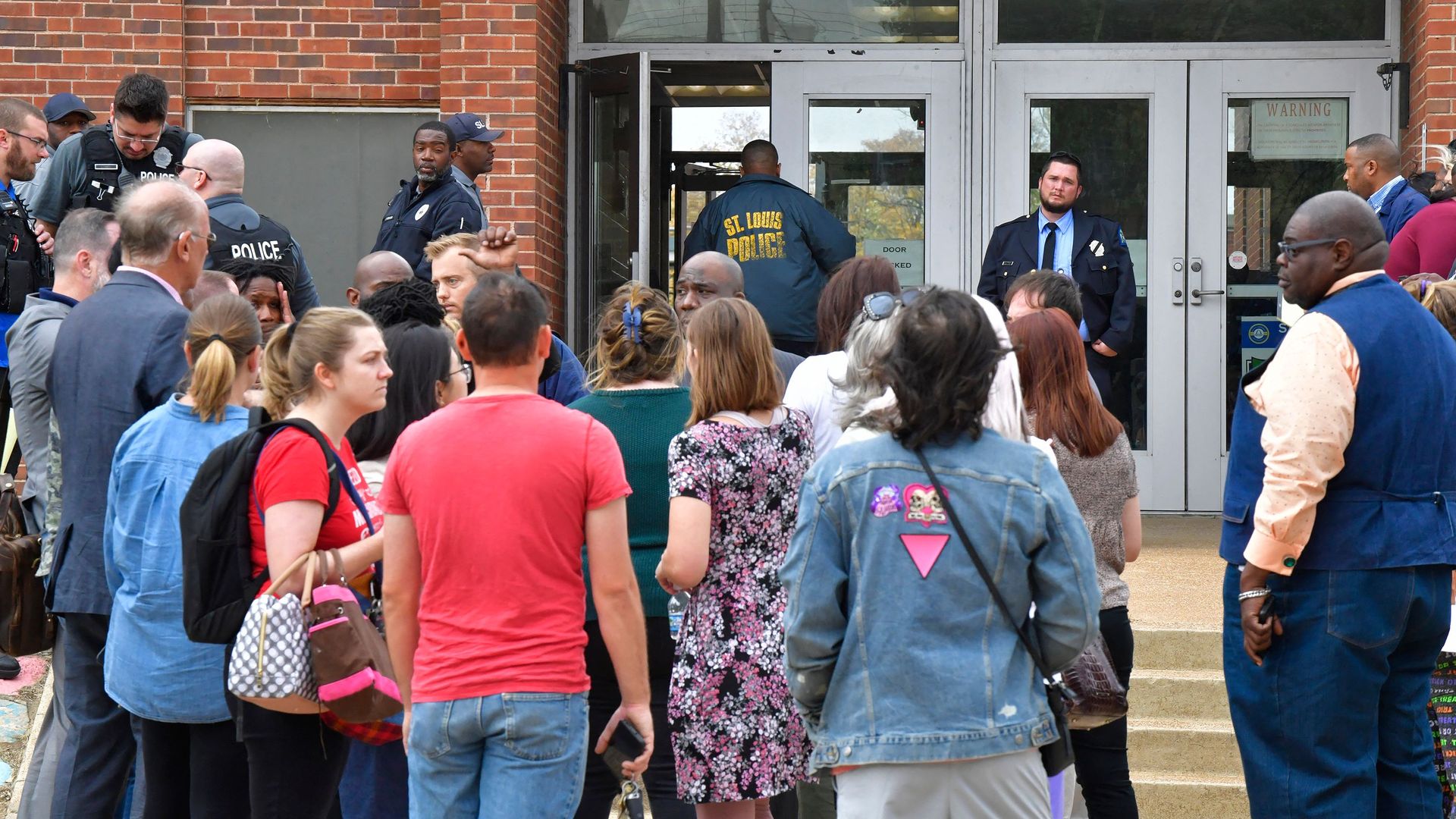 St. Louis metropolitan police and school officials stand outside  Central Visual and Performing Arts High School after a shooting  in St Louis, Missouri on October 24.