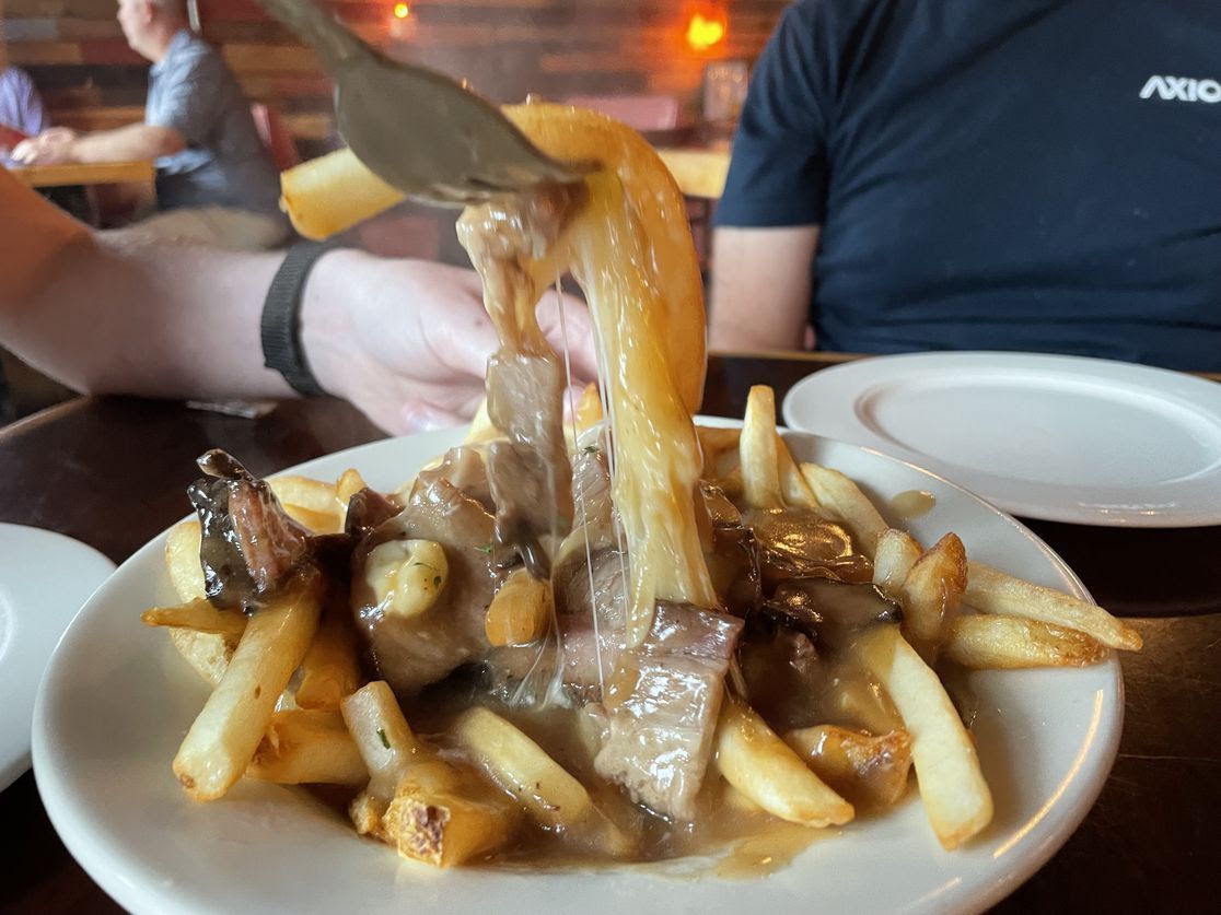 Cheese pulled from poutine at Des Moines' Angry Goldfish pub.