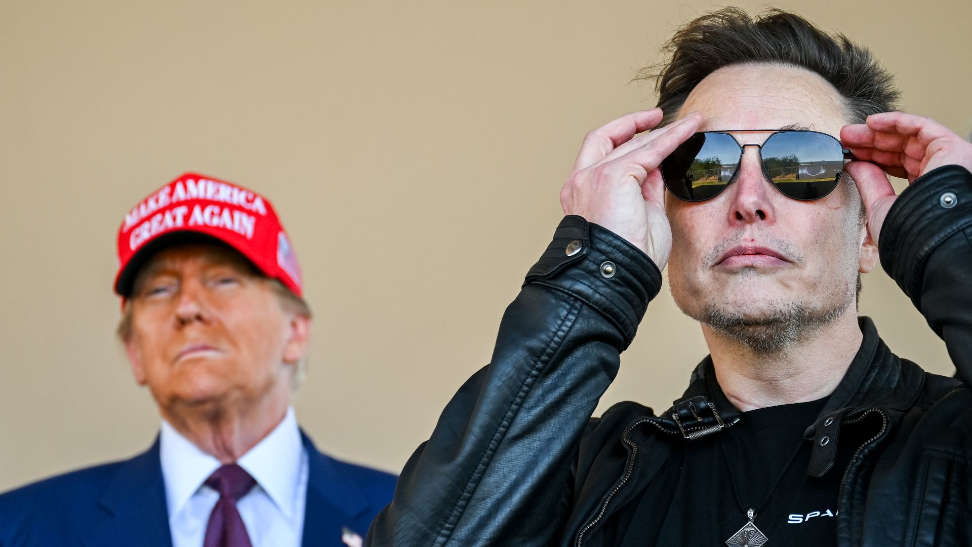 Elon Musk watches a SpaceX launch, with Donald Trump standing behind him.