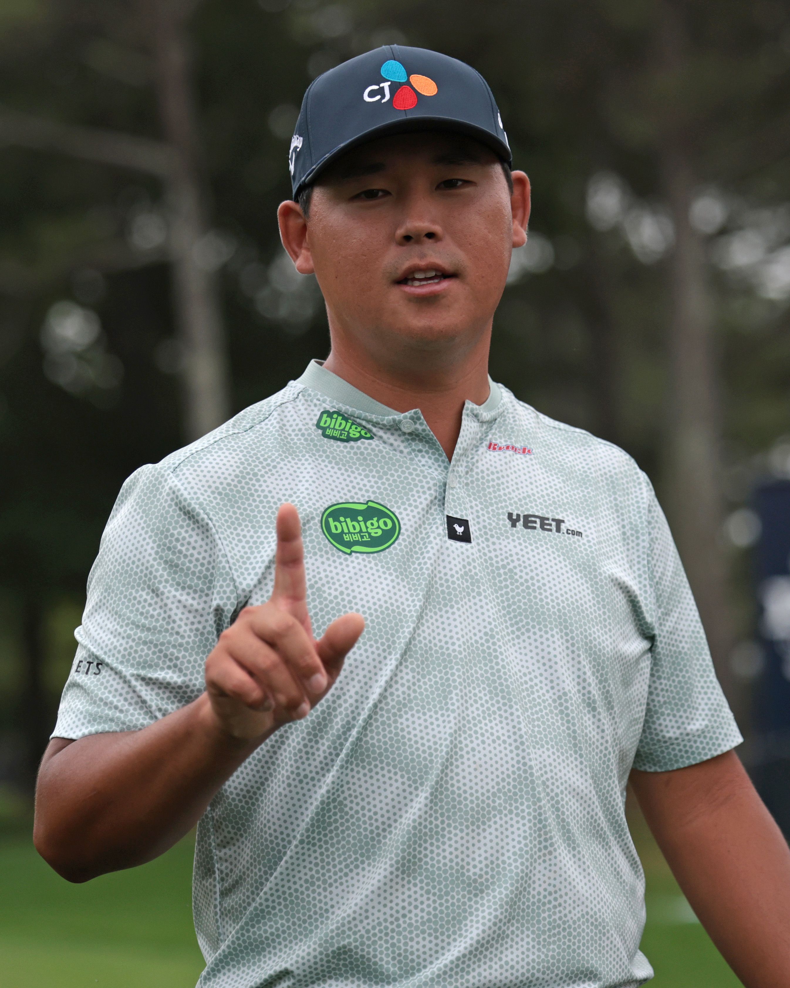 Si Woo Kim's holds up a "No. 1" after his hole-in-one.