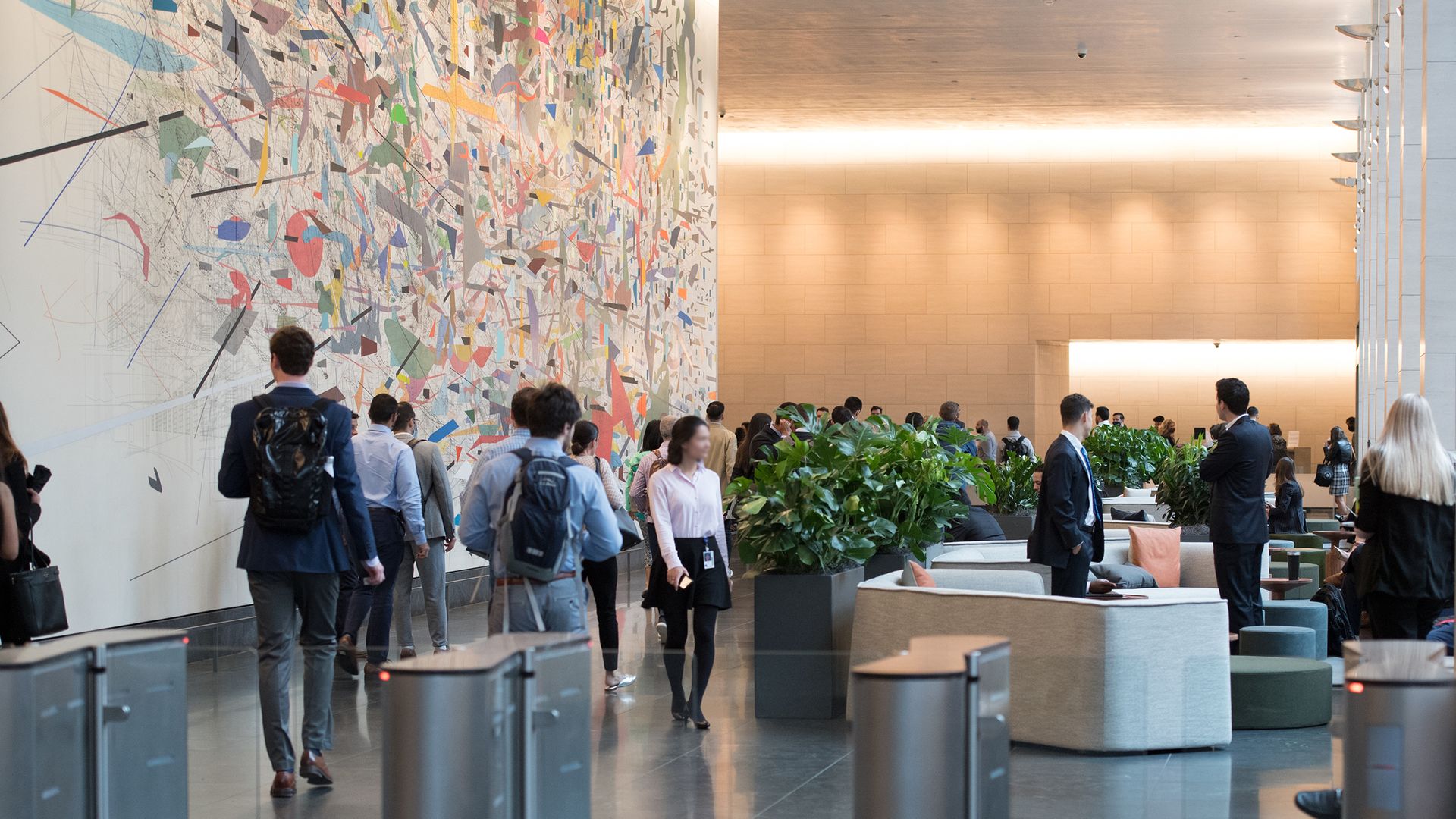 Goldman Sachs bankers walk past the Julie Mehretu "Mural" at their NY headquarters
