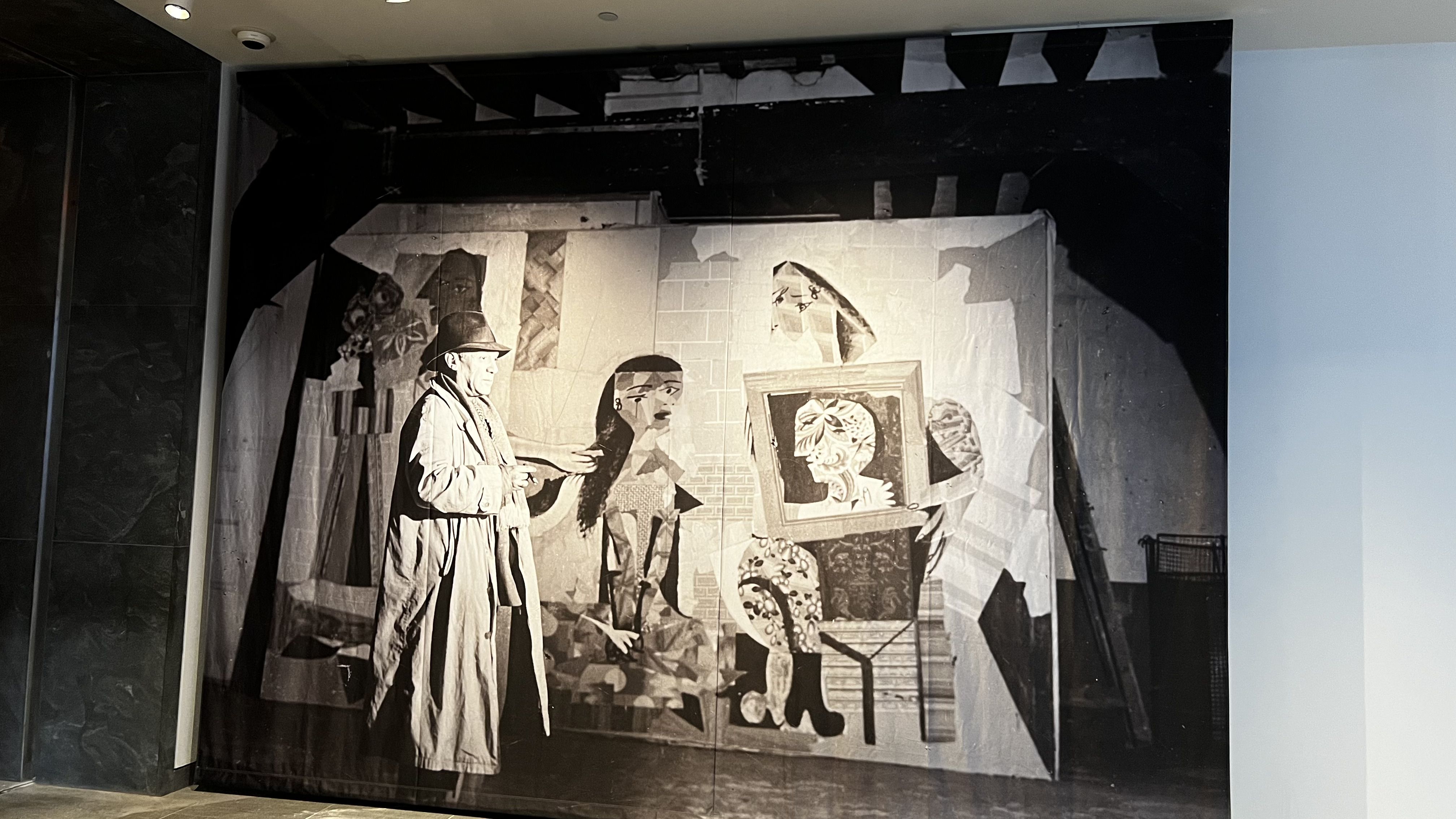 An mural of Pablo Picasso in front of his "Women at Their Toilette" wallpaper college. 