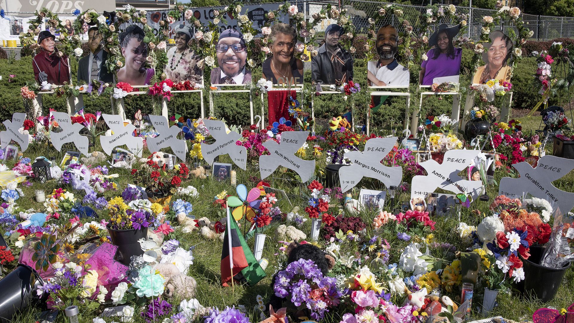 Street memorials of flowers and candles and messages surround the Tops supermarket where a racist gunman murdered ten African Americans with an assault rifle, June 18, 2022