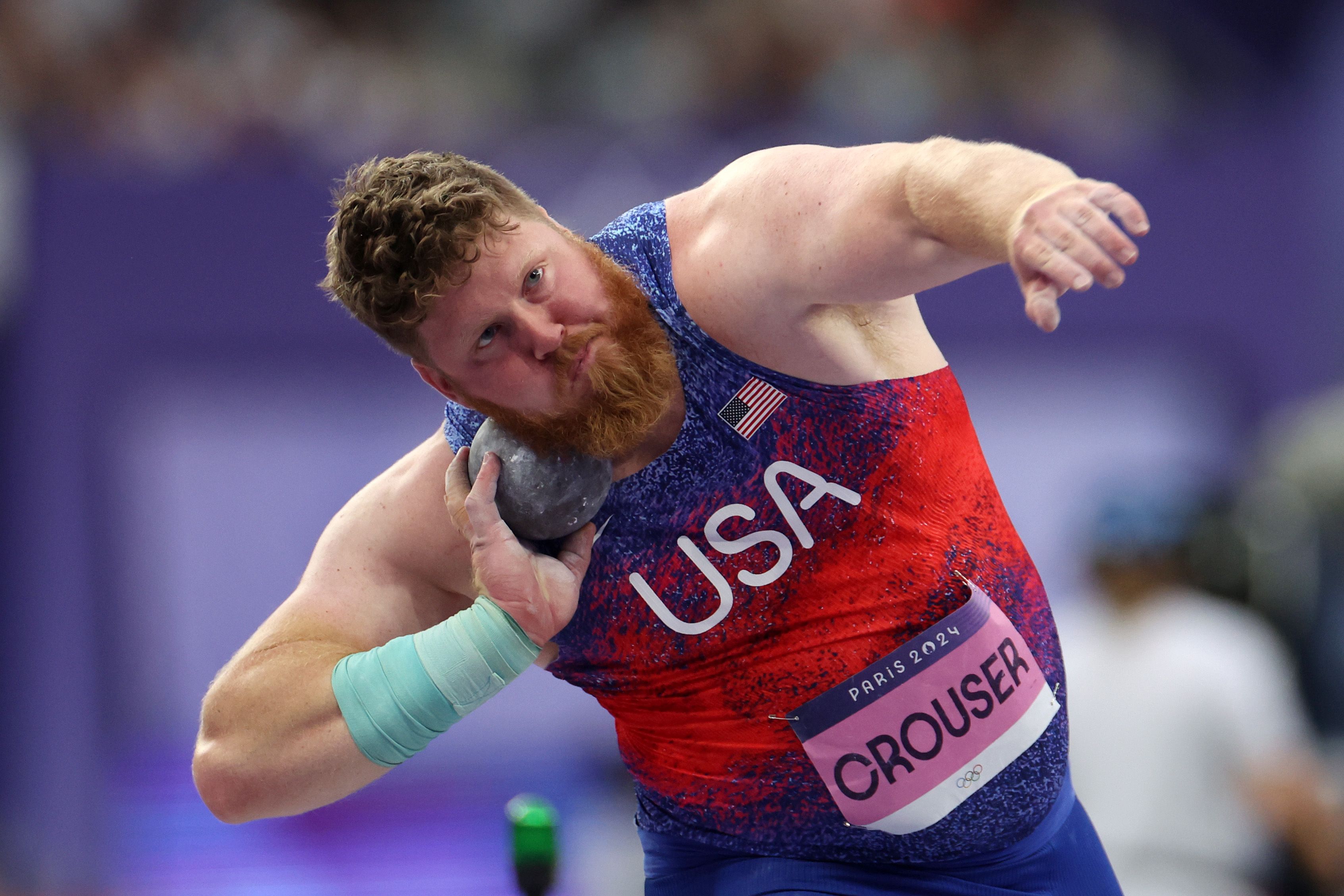 A person holds a shot put ball in their hand.