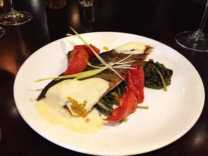 Campfire Trout with roasted tomatoes, pickled greens, cornbread purée and trout caviar.