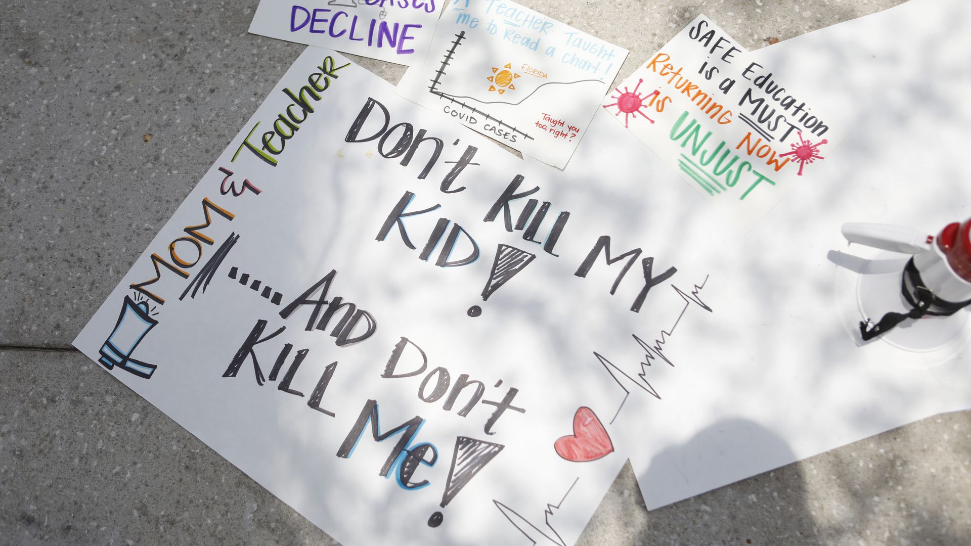Protest signs on the ground against the reopening of the schools during the coronavirus pandemic