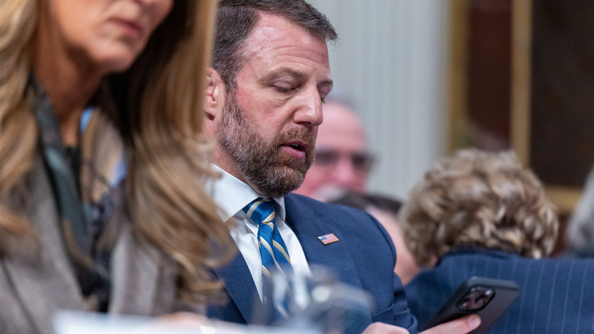 Homeland Security Secretary looks at his phone during a meeting at the White House.
