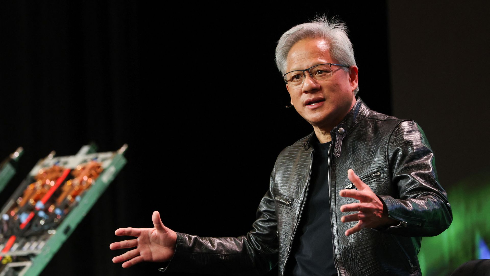 Man in a shiny leather jacket with his hands out in front of him