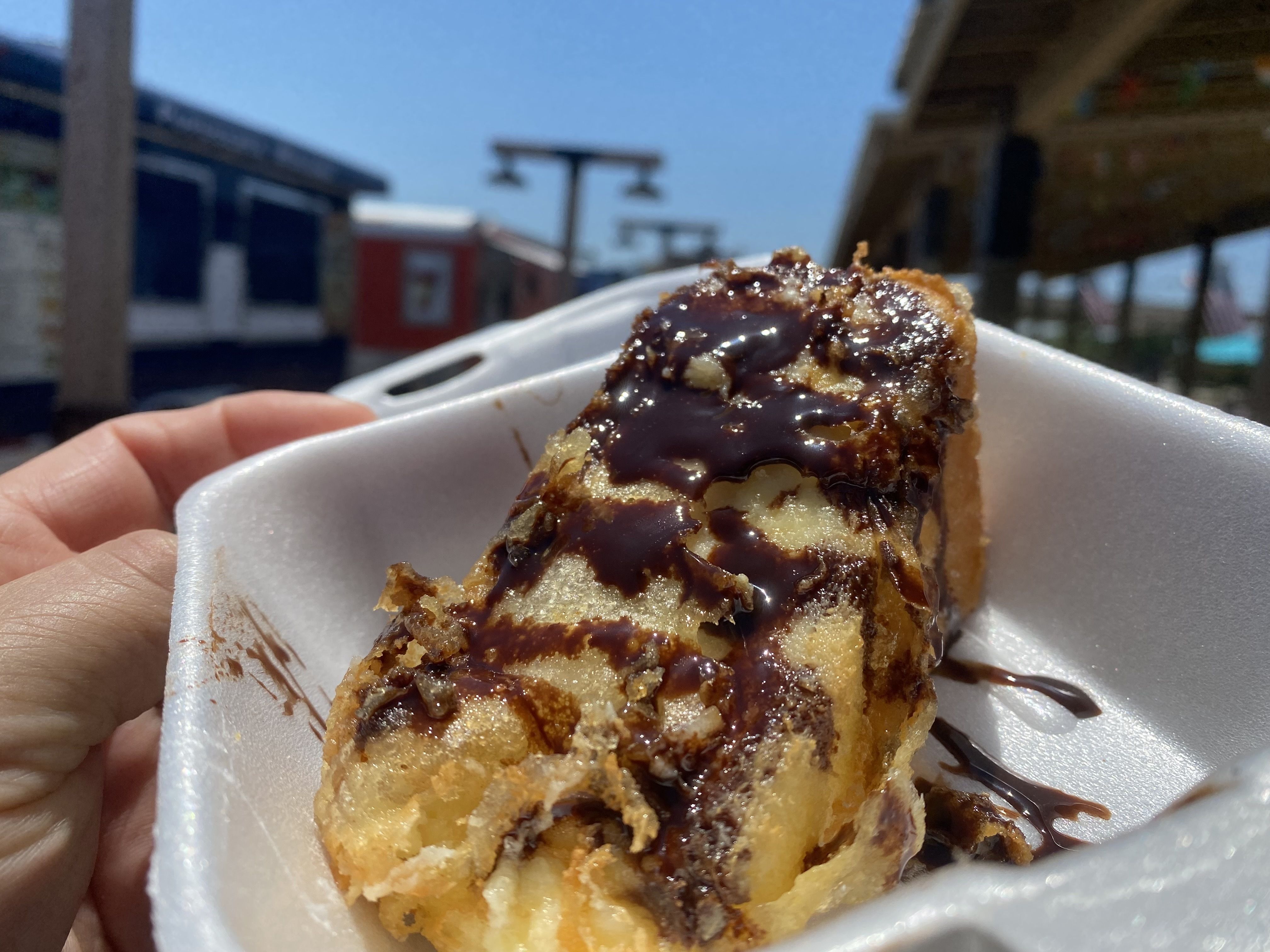 A photo of fried cheesecake drizzled with chocolate sauce. 