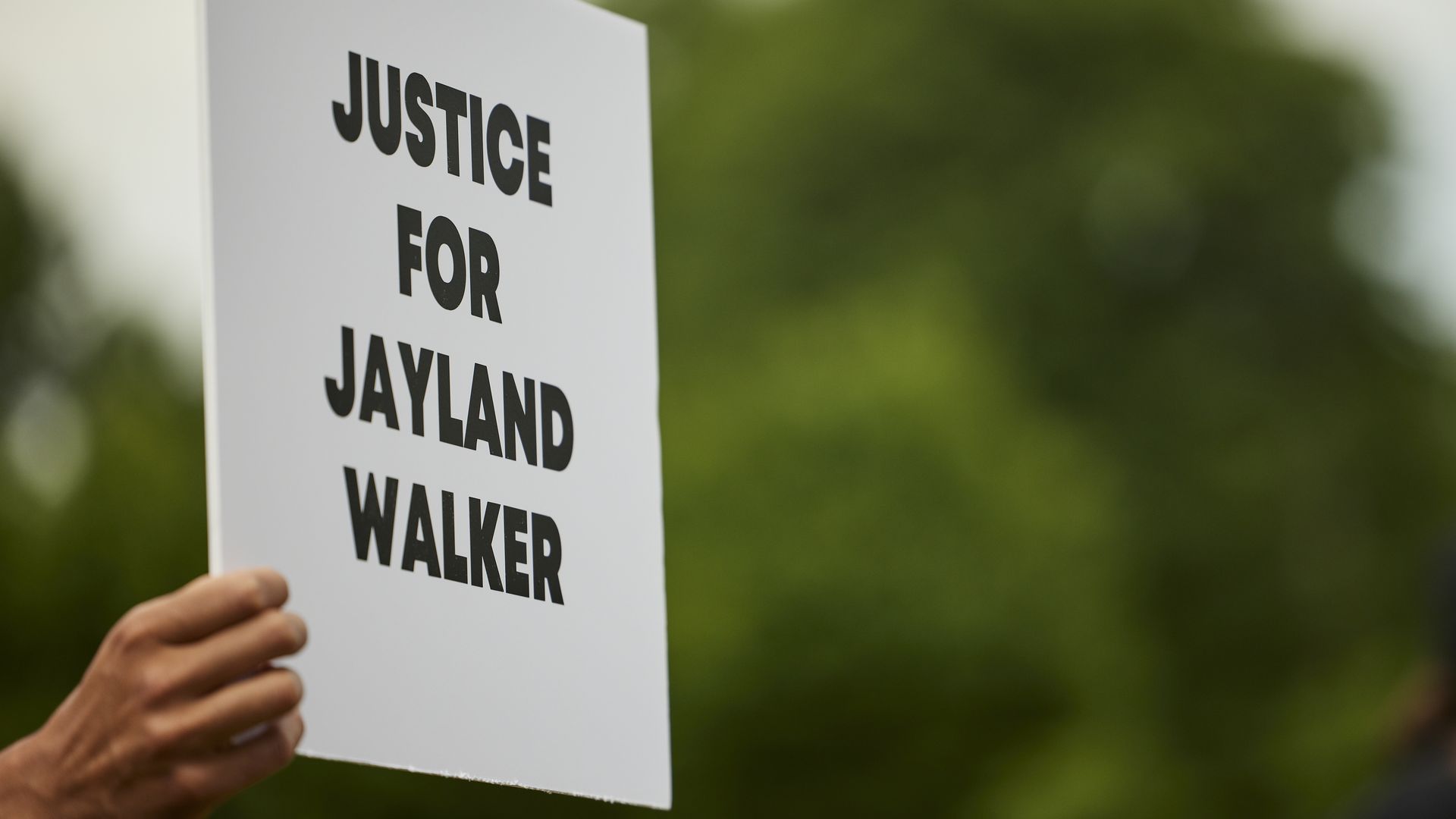 A demonstrator holds a sign during a vigil in honor of Jayland Walker on July 8, 2022 in Akron, Ohio. Photo: Angelo Merendino/Getty Images)