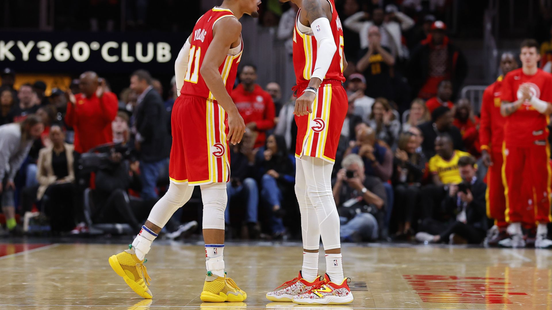 TrTrae Young and Dejounte Murray talk to each other on the court during a Hawks game