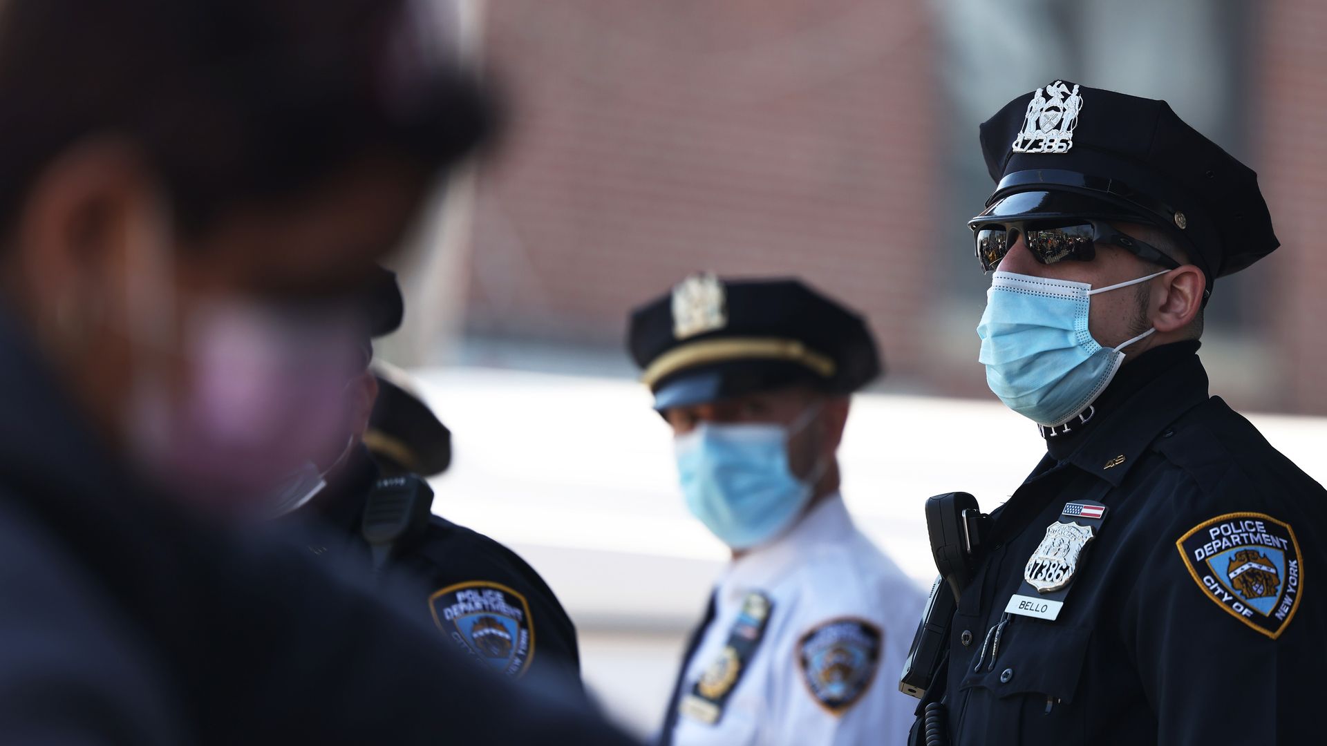 Photo of two NYPD officers in uniform and wearing face masks standing outside