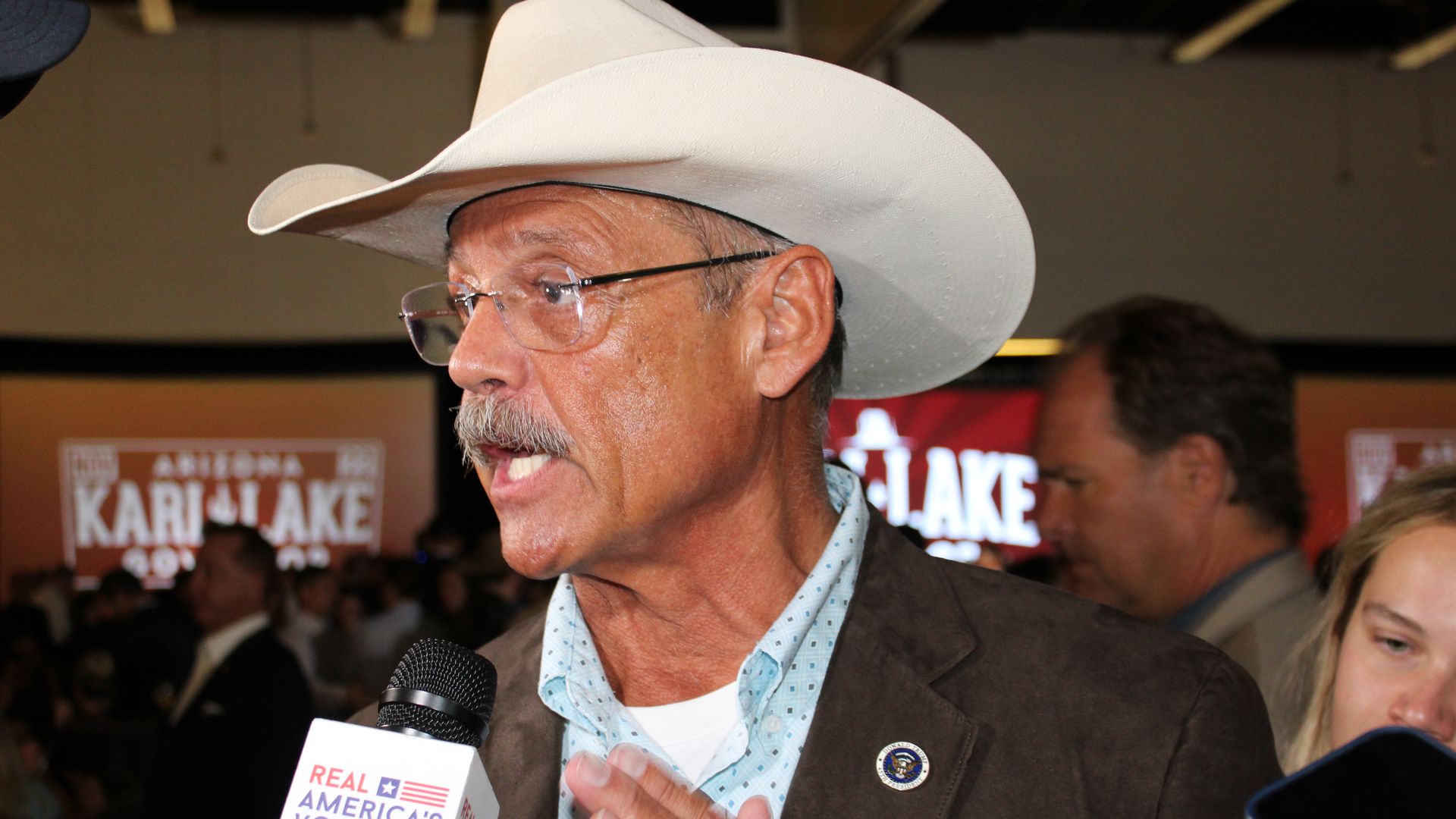Mark Finchem gestures with his hand while speaking to a reporter