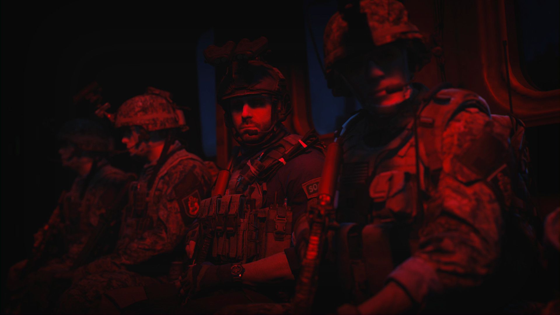 Video game screenshot of soldiers sitting in a helicopter under a red light