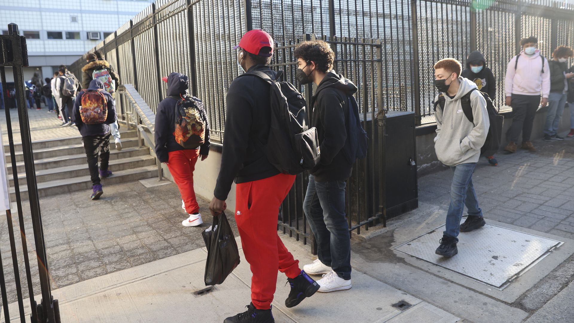 Students wait in line to enter a New York City public high school in New York.