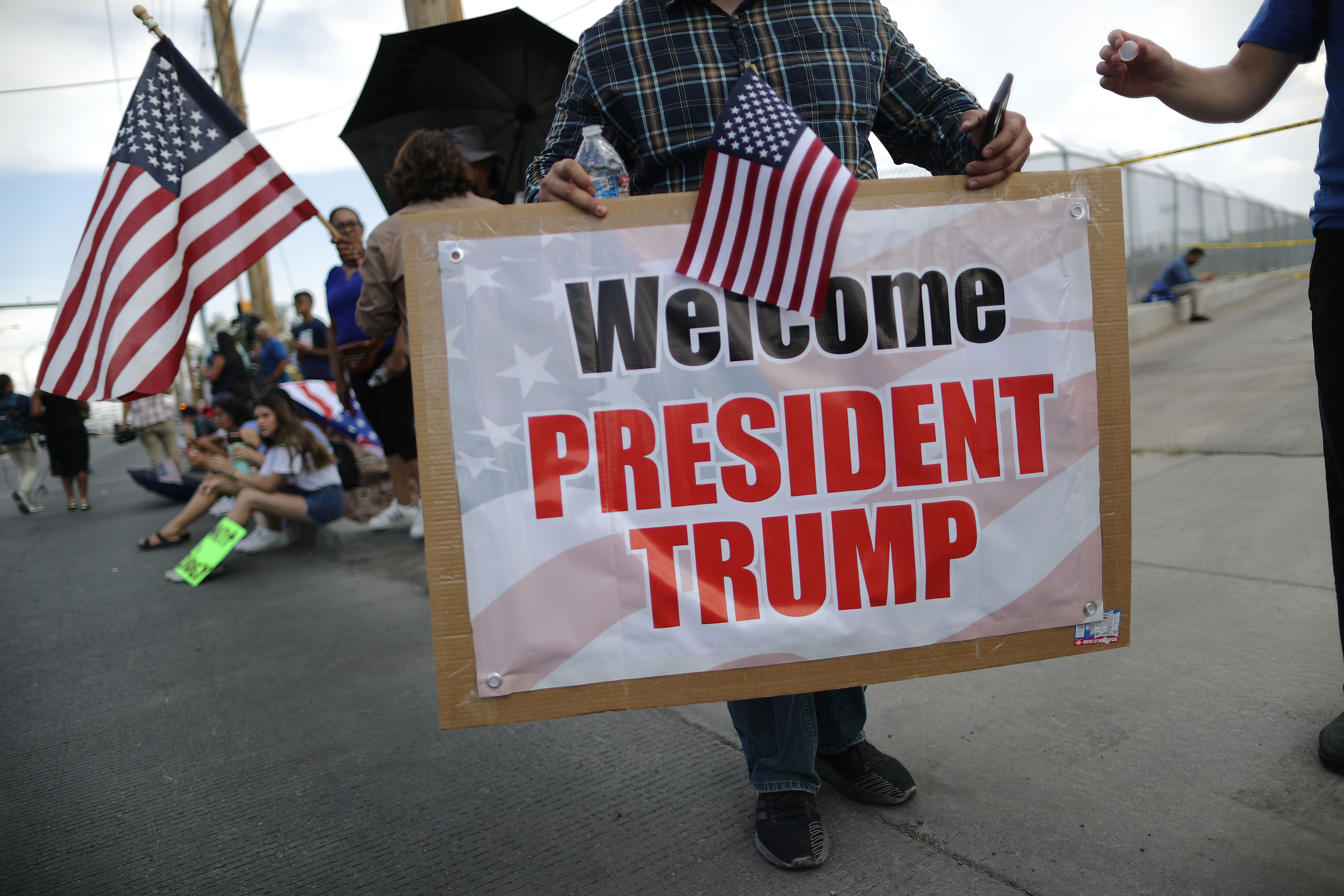 A Trump supporter holds a 'Welcome President Trump' sign outside University Medical Center