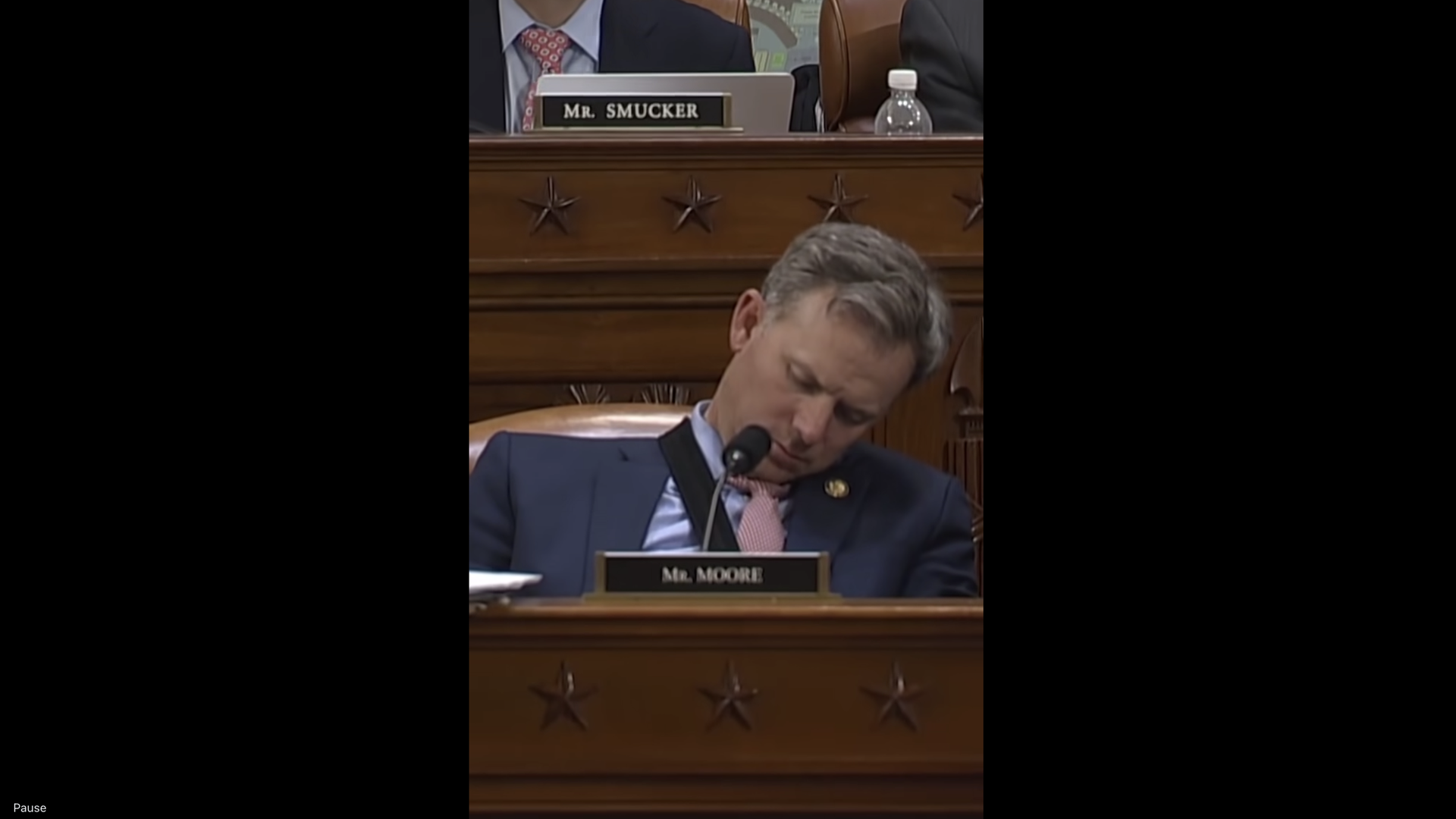 Rep. Blake Moore sleeps at his seat in the U.S. Capitol behind a plaque with his name.