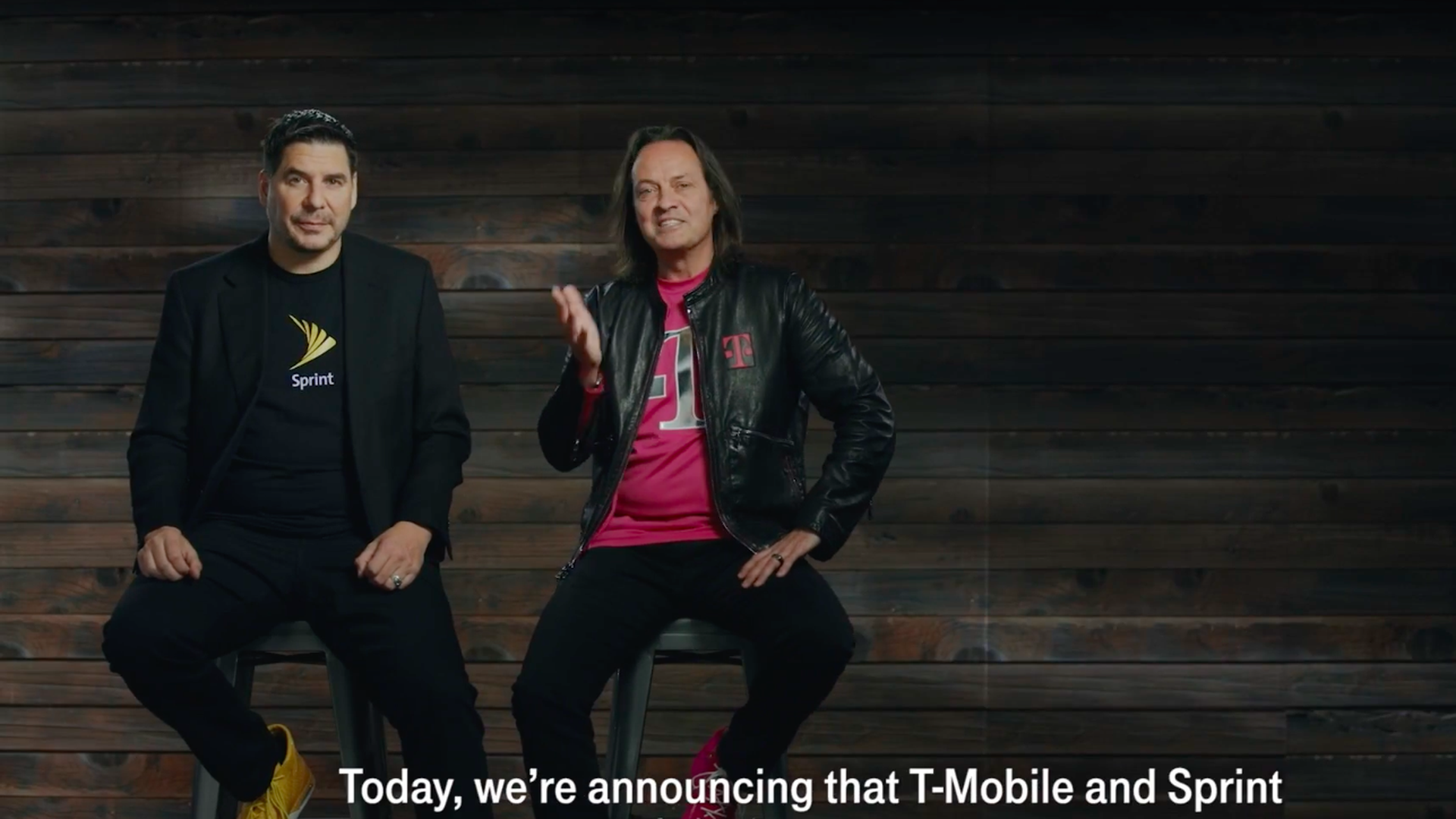 Sprint CEO Marcelo Claure and T-Mobile chief executive John Legere sit on high stools