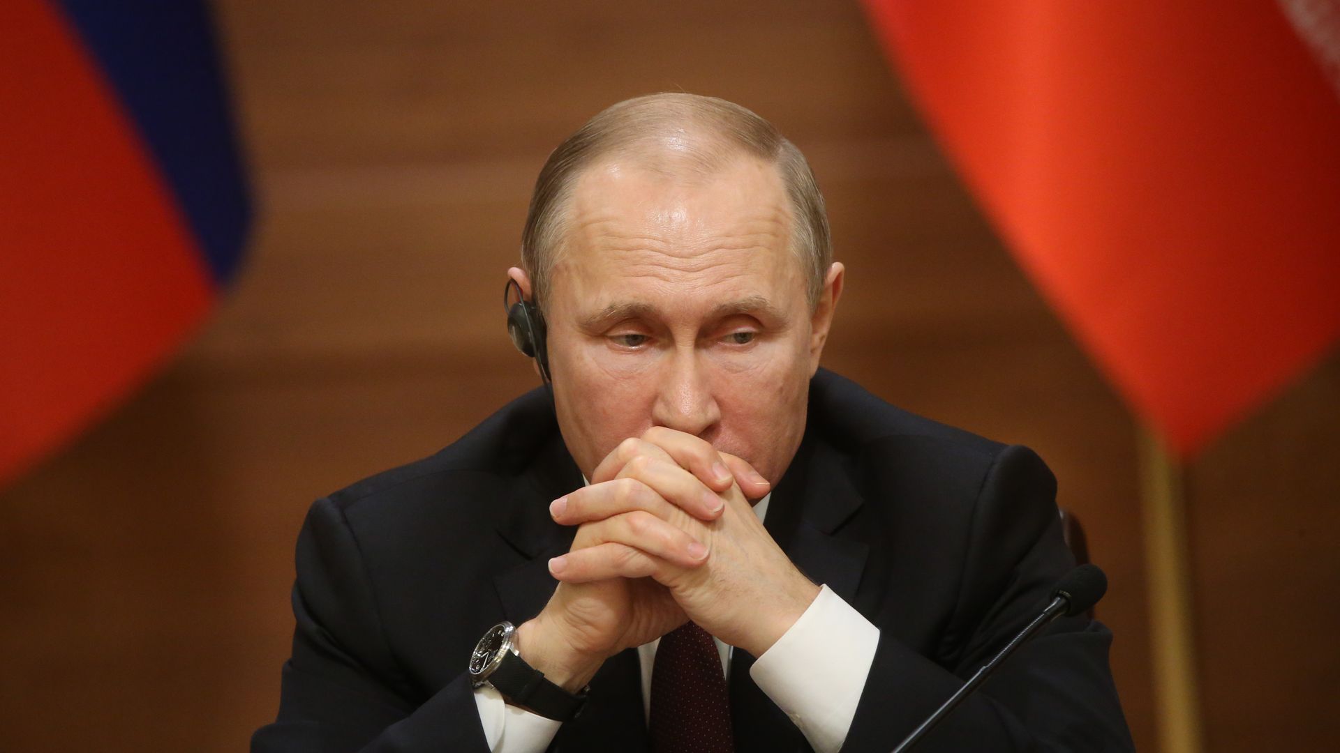 Vladimir Putin rests his head on steepled hands.