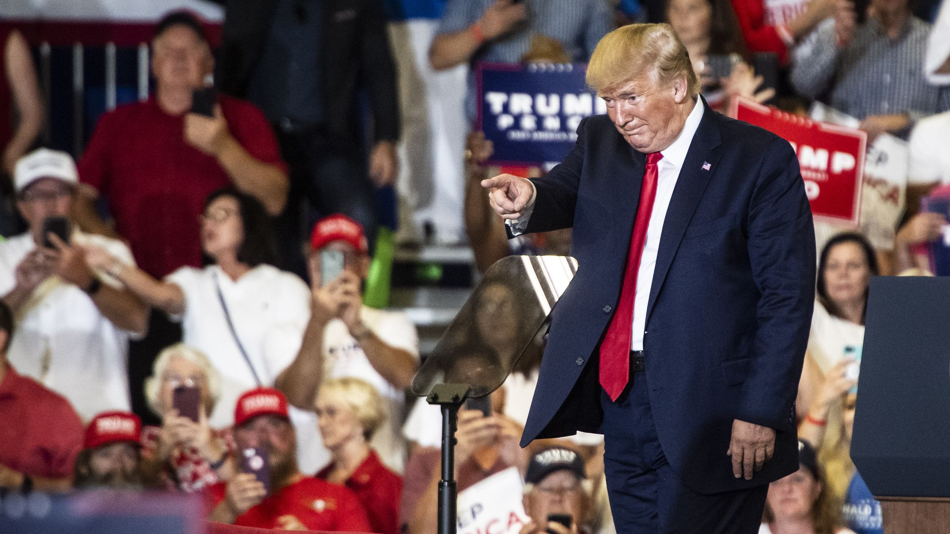 In this image, Trump points at a MAGA rally attendee 