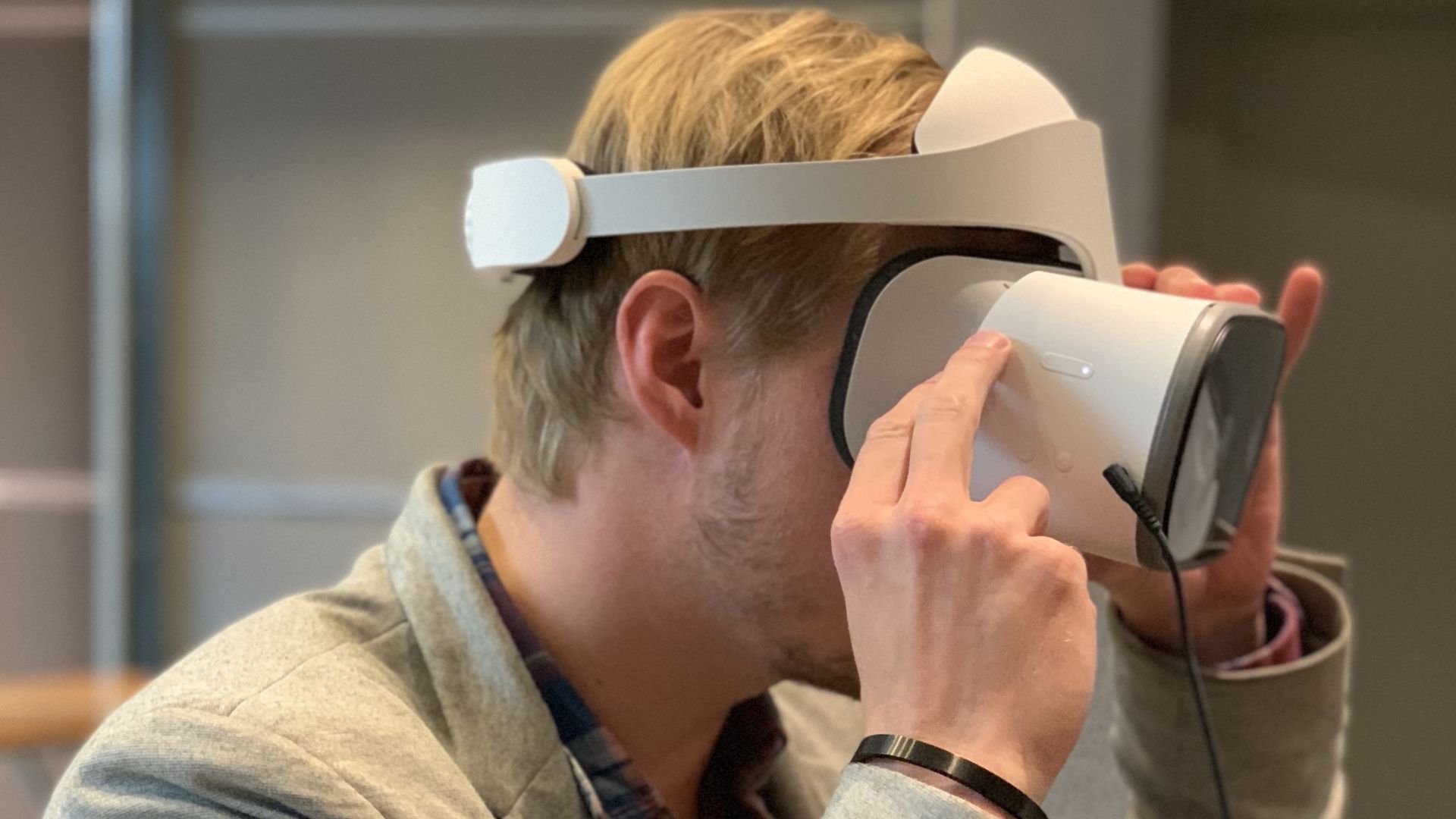 A seated man wears a virtual reality headset