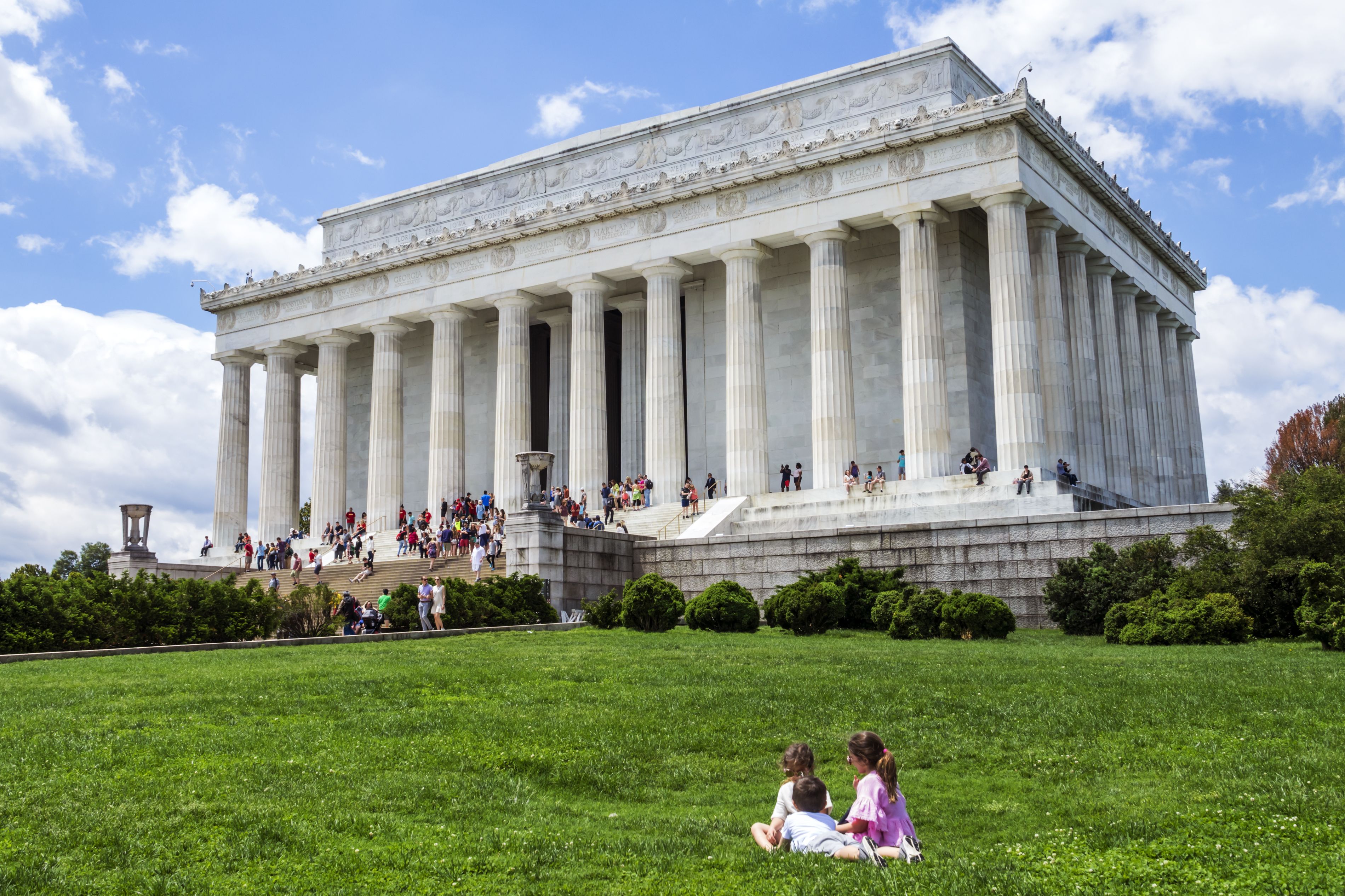 Children sit in front of the Lincoln Memorial