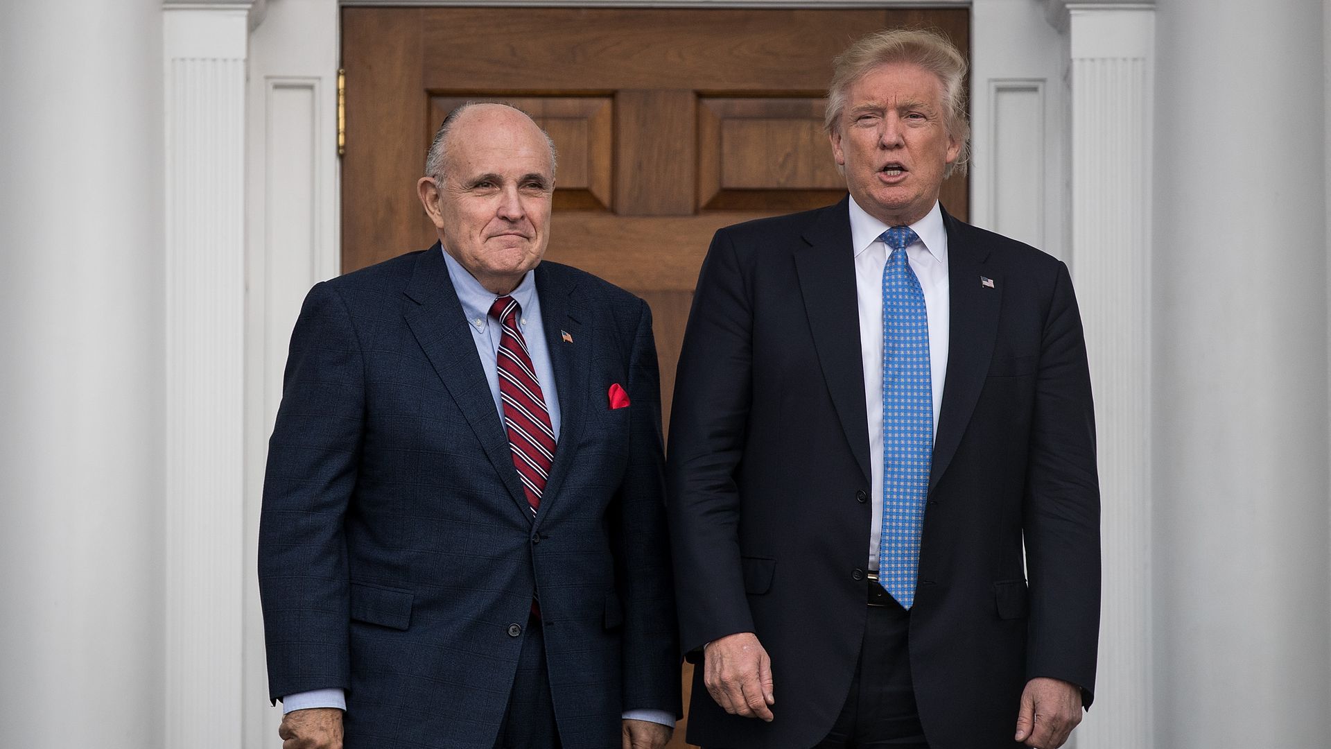 Former New York City mayor Rudy Giuliani stands with president-elect Donald Trump before their meeting at Trump International Golf Club