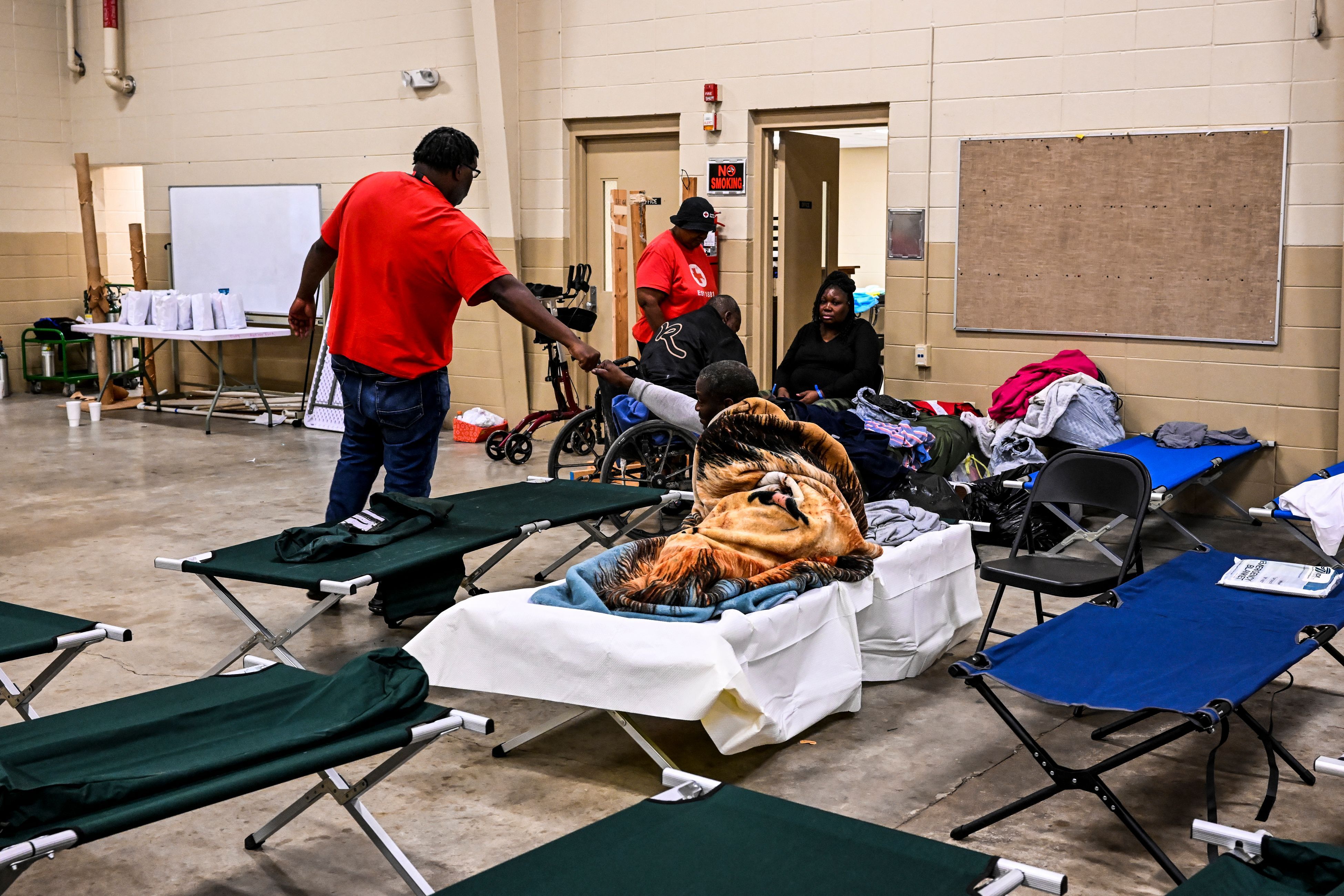 A man fist bumps a person sheltering inside a makeshift clinic and relief center in Rolling Fork, Mississippi after a tornado.