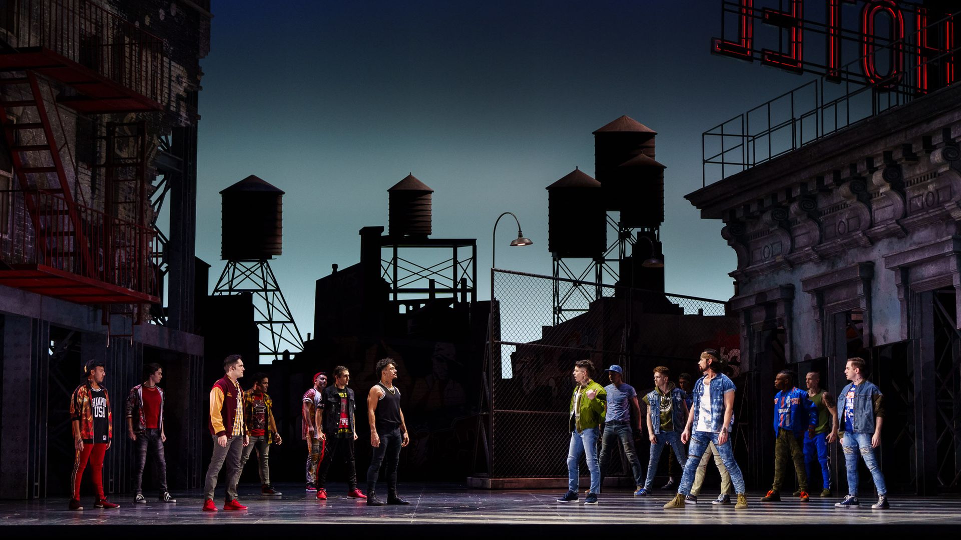 Photo of west side story on stage, with the two groups on different sides. 