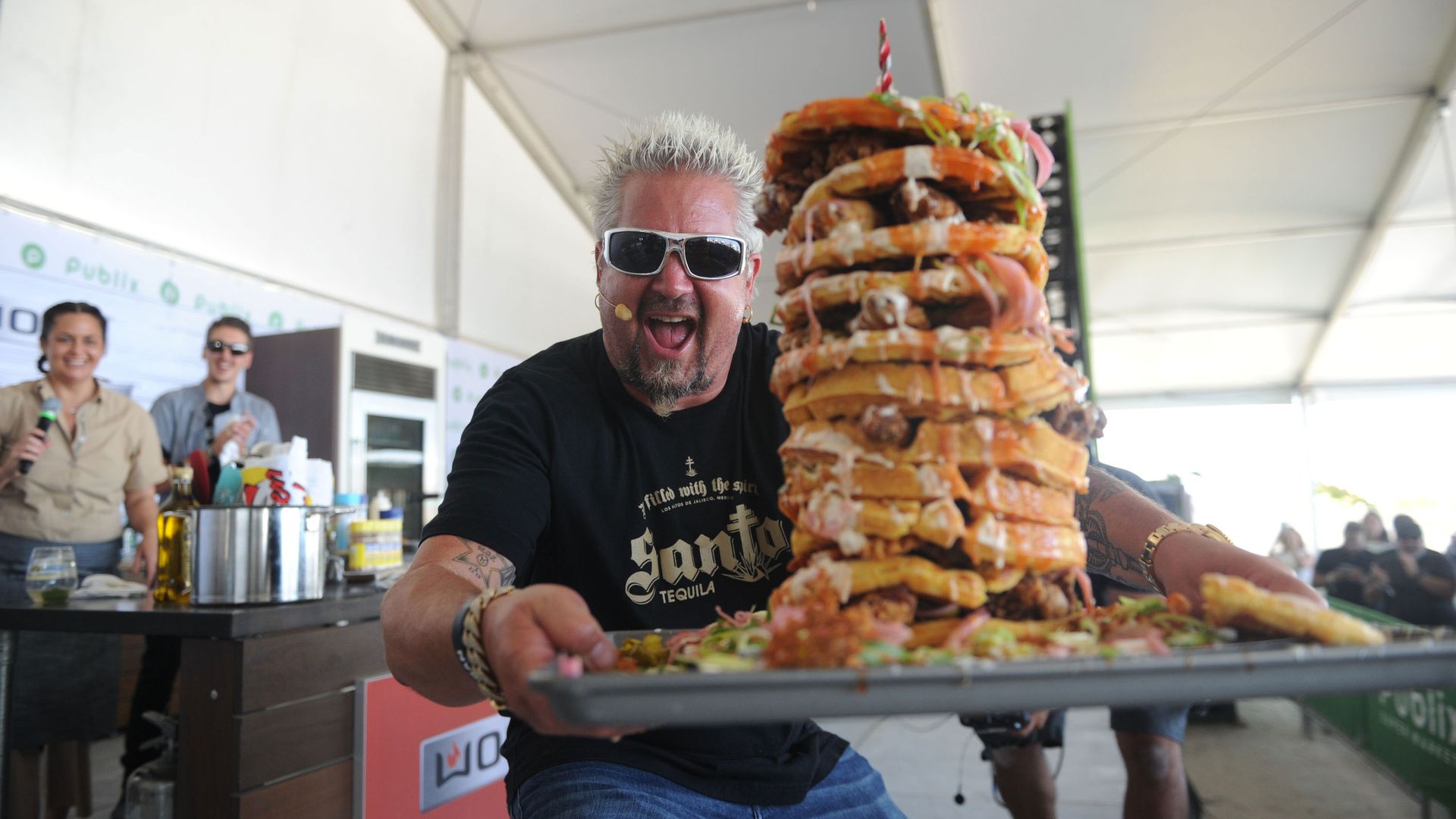 Guy Fieri holds a tray with a stack of waffles