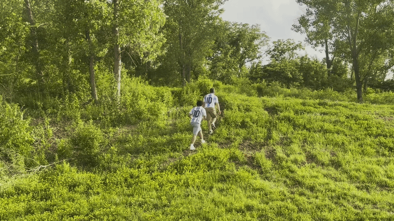 GIF shows video of Argentina fans walking up grassy berms along the highway and hopping fences to get to the stadium.