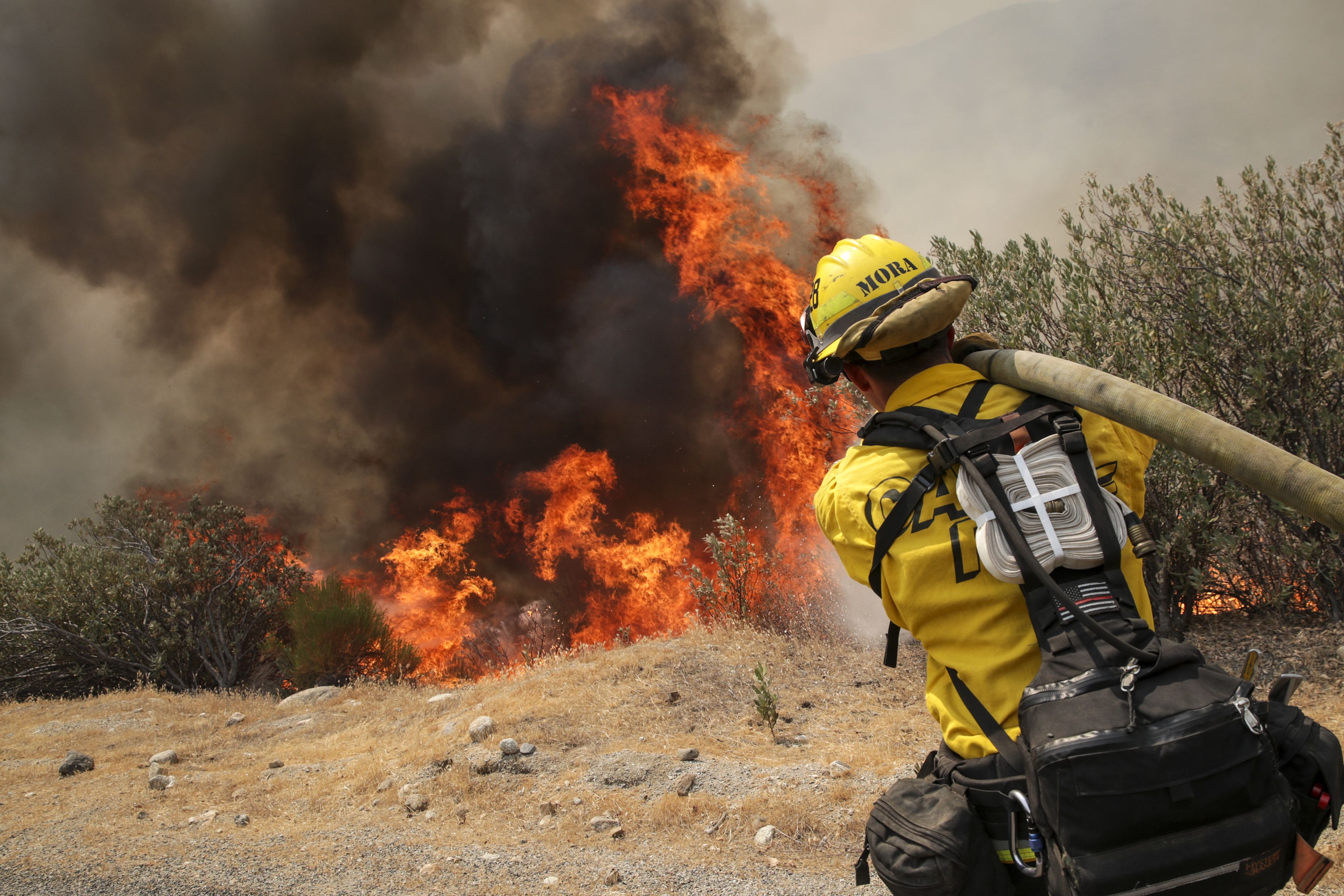 A firefighter hosing down flames from the Fairview Fire near Hemet, California, on Sept. 7.