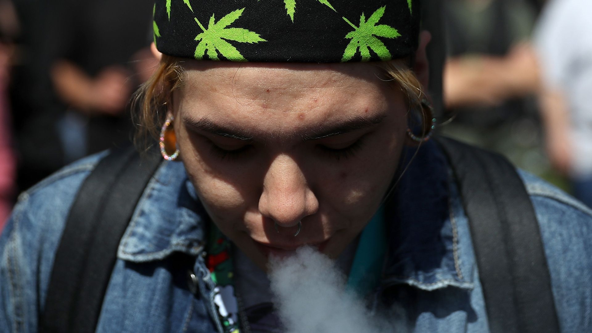 Photo of a person wearing a headband with the marijuana plant smoking