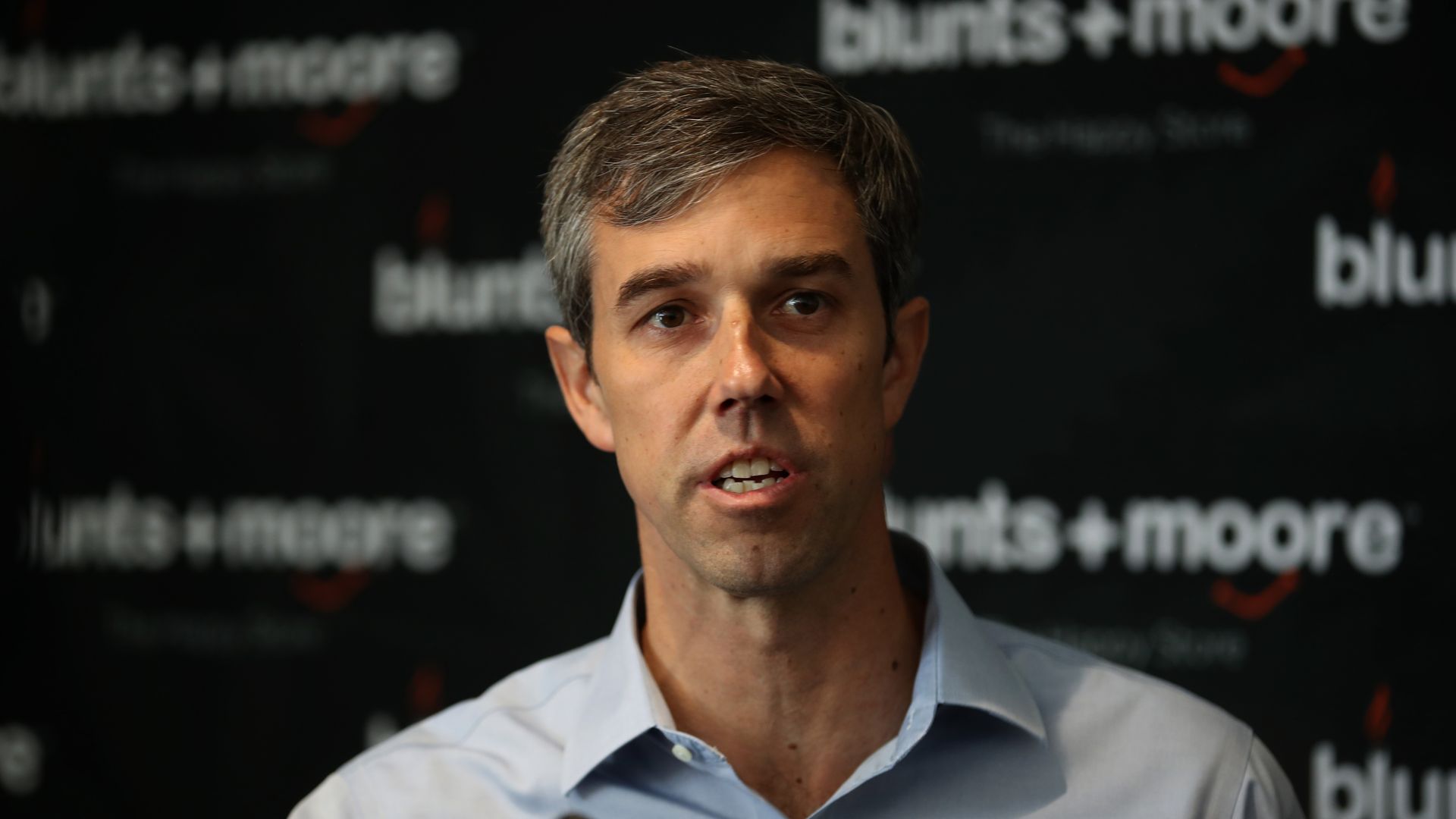 Beto O'Rourke holds a microphone.