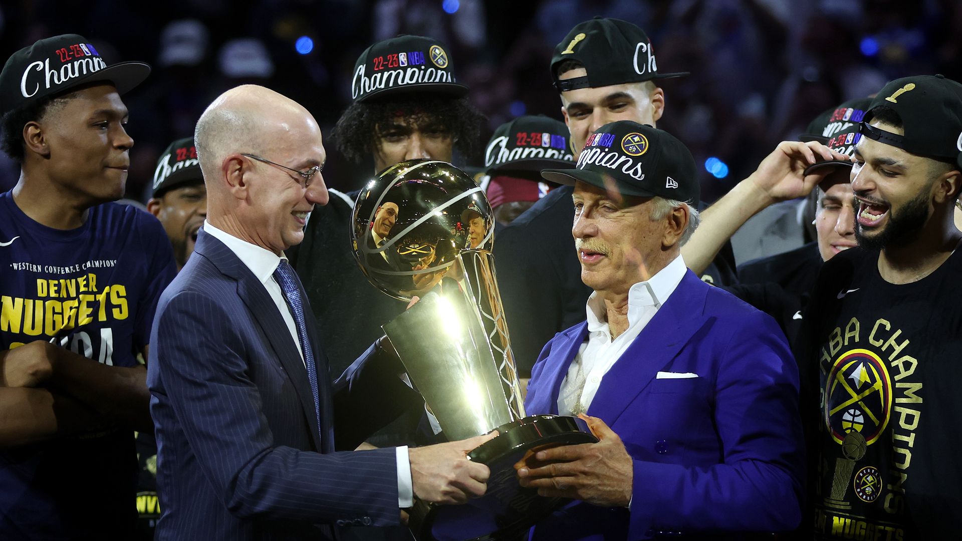 commissioner handing trophy to nuggets owner