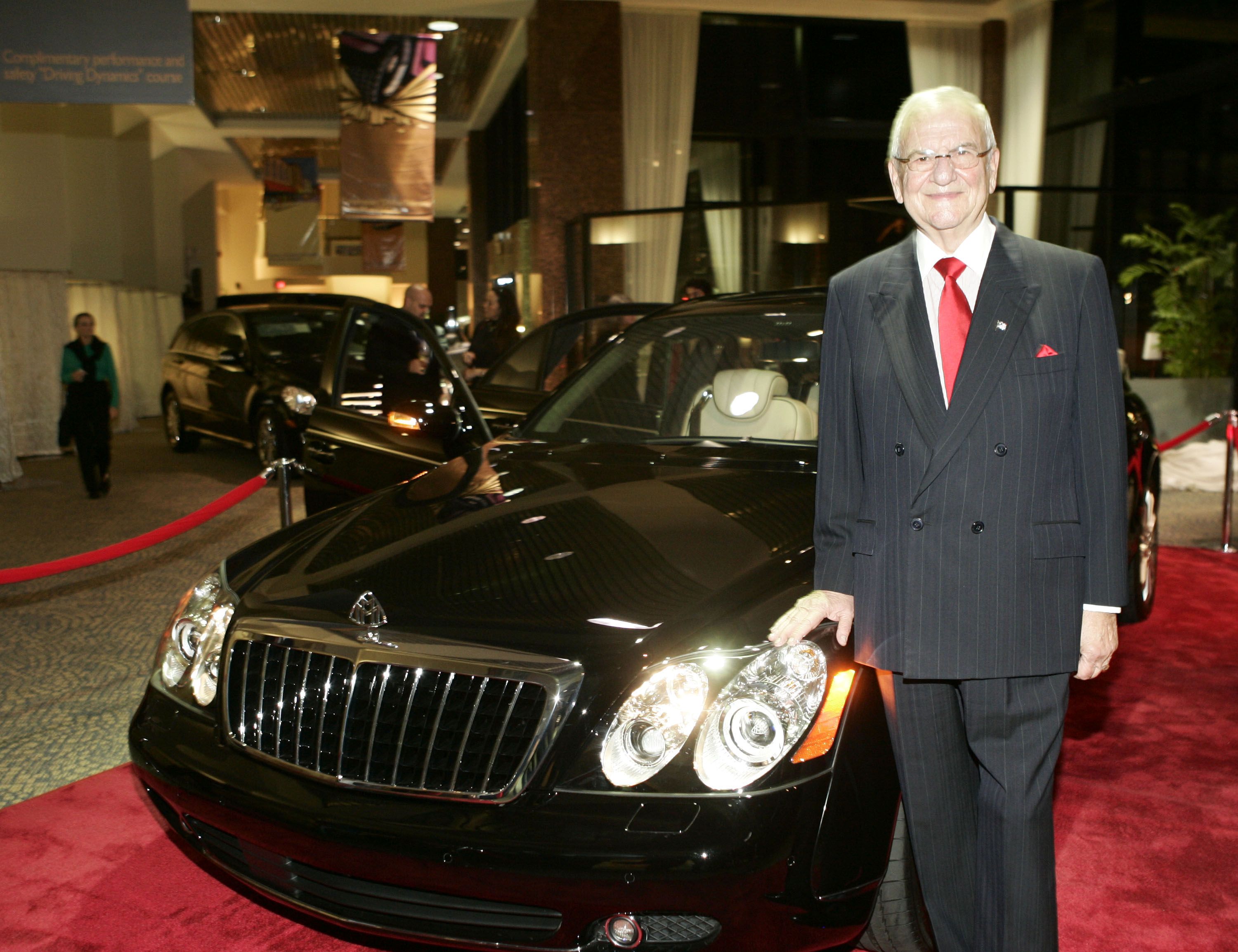 In this image, Lee Iacocca stands in front of a Benz