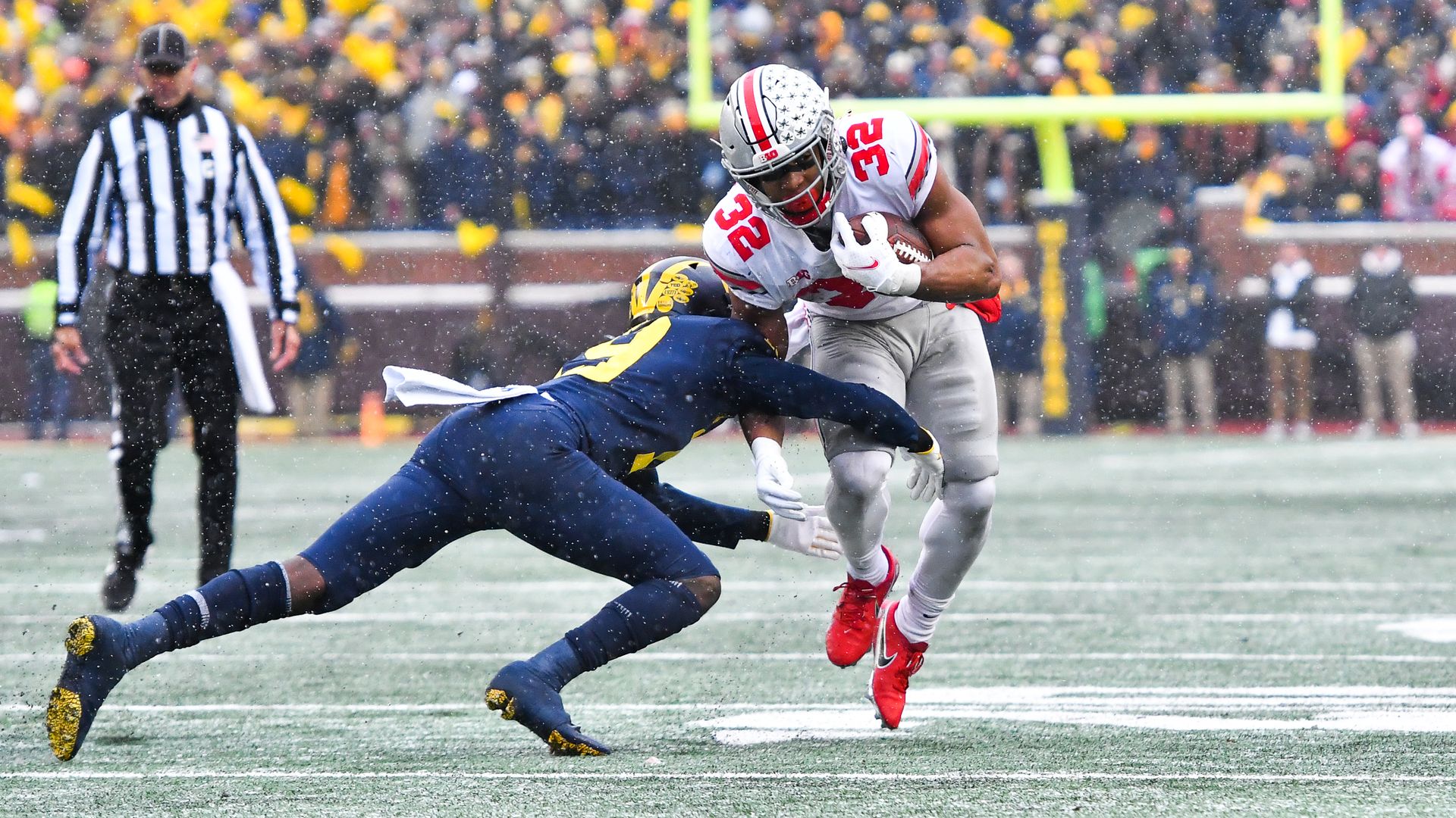 An Ohio State football player tries to evade a Michigan defender. 