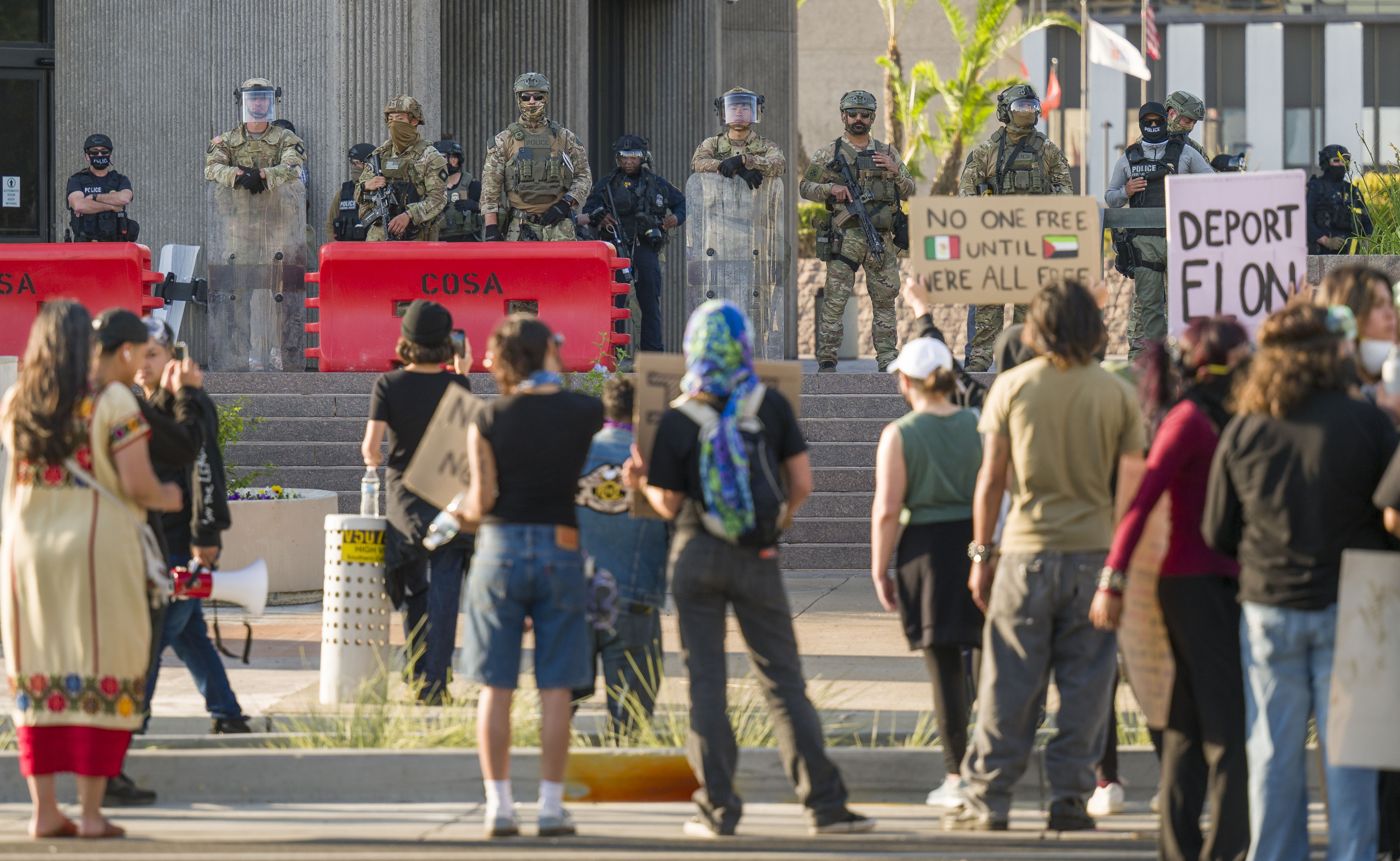 Federal law enforcement stand guard as protesters gather at the Federal Building in Santa Ana on Tuesday, June 10, 2025. 
