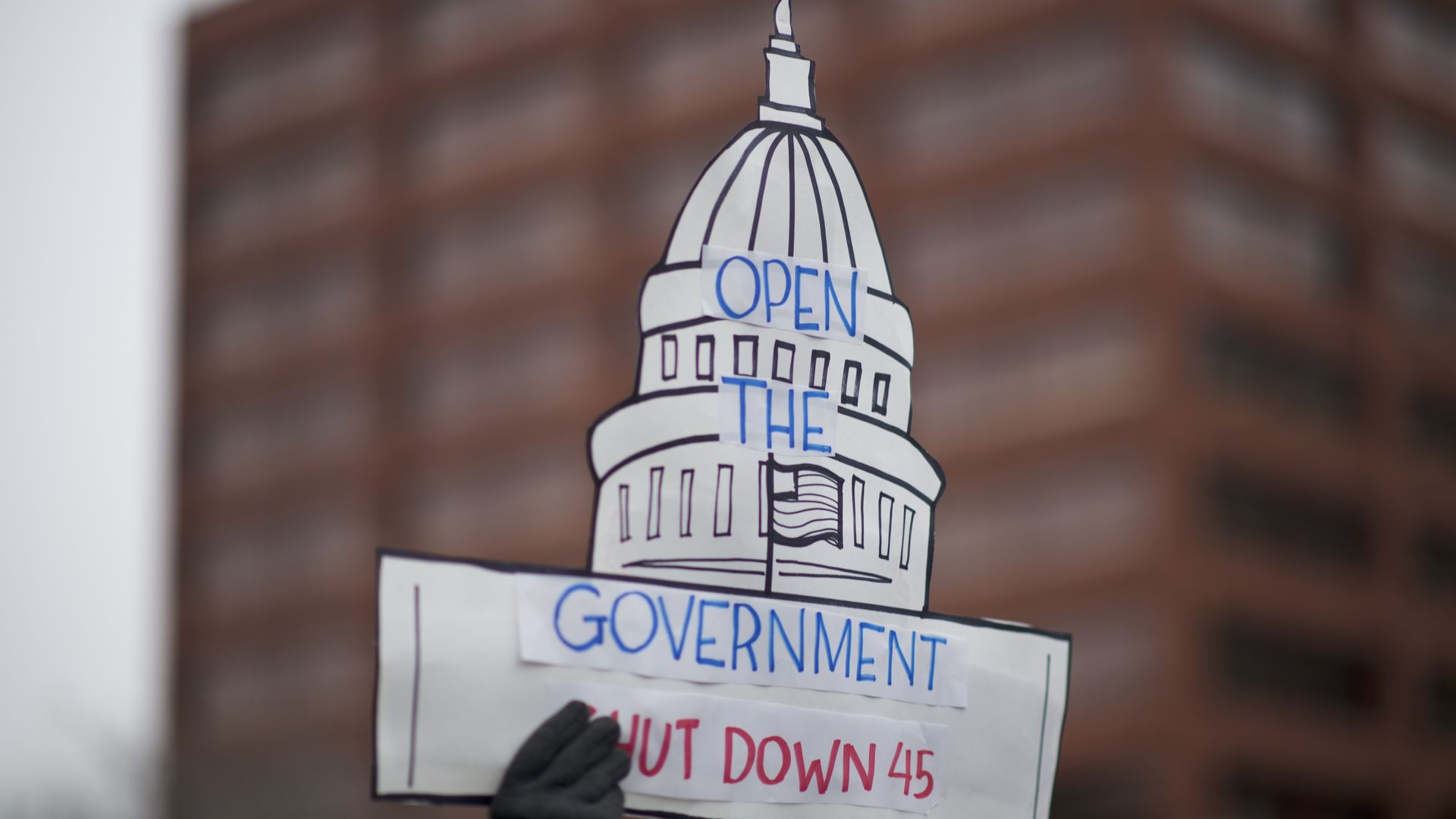 Protestor holds up sign urging Donald Trump to end shutdown