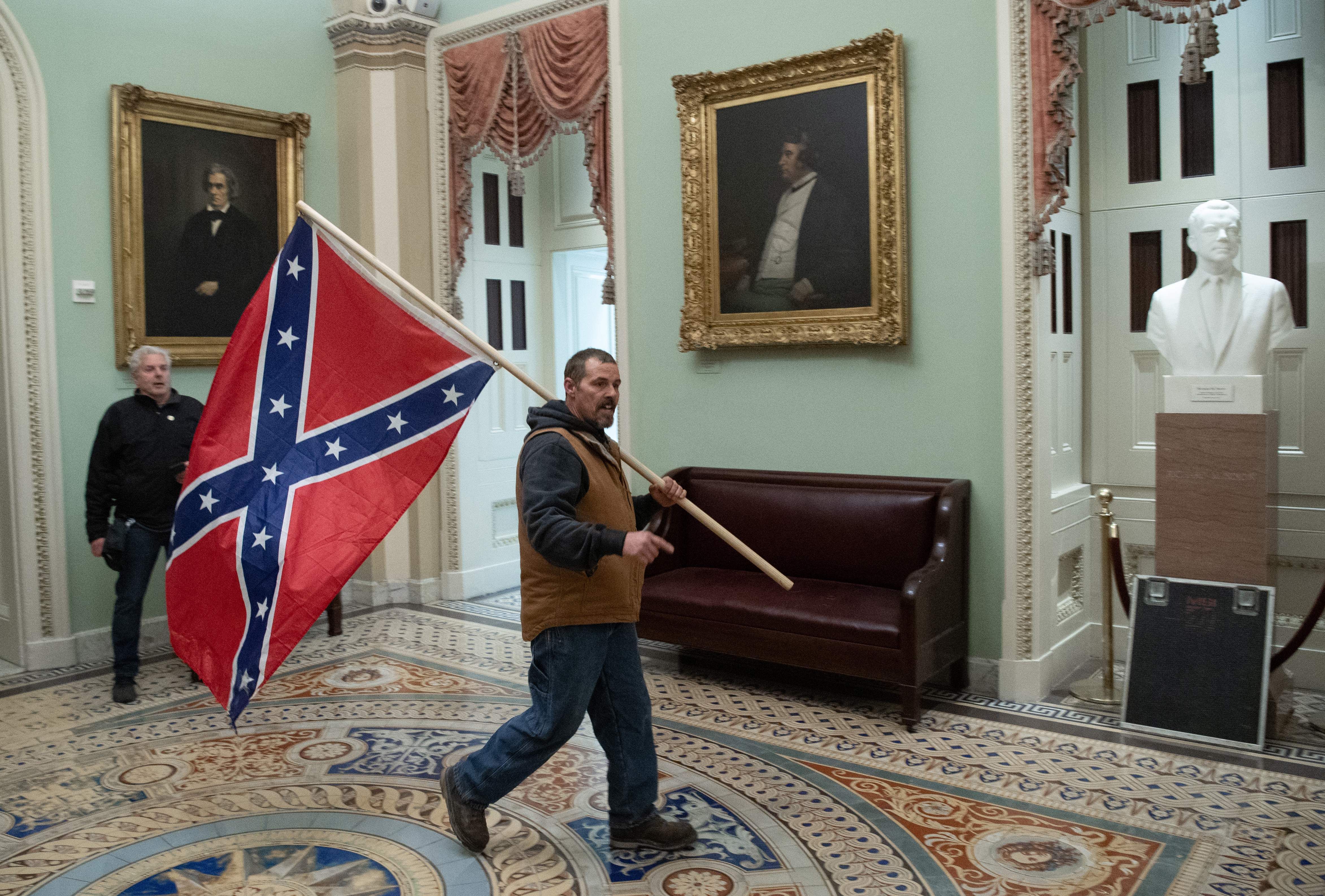 A protestor is seen carrying a Confederate flag through the U.S. Capitol today.